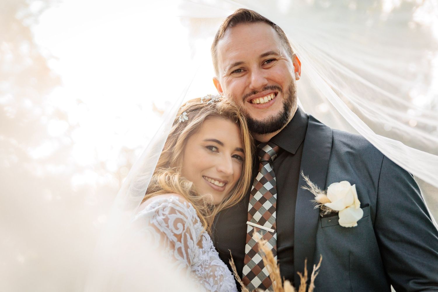A romantic wedding moment captured with soft lighting and white floral bouquet details.