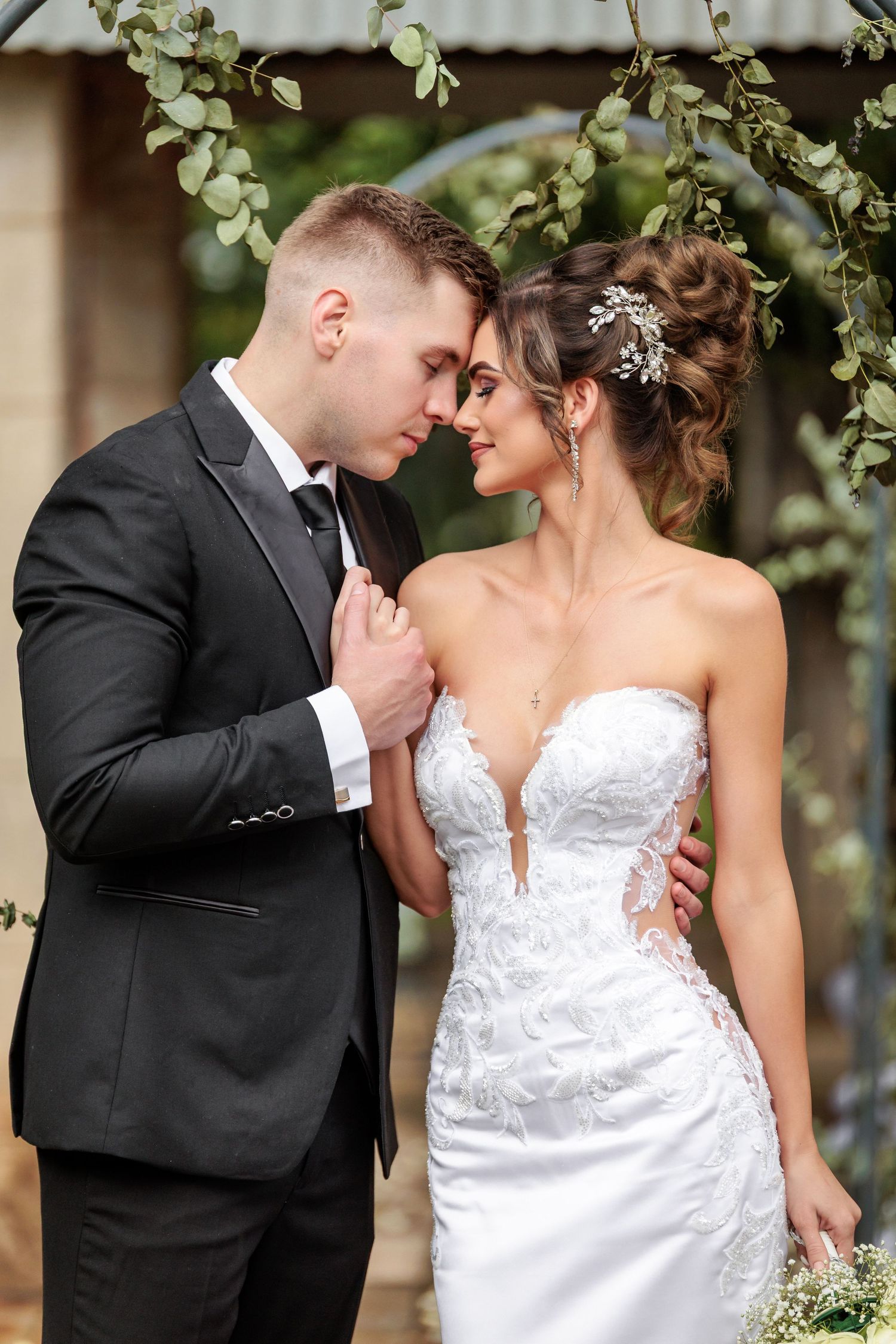 A romantic series of wedding photos showing tender moments between newlyweds against a leafy outdoor backdrop.