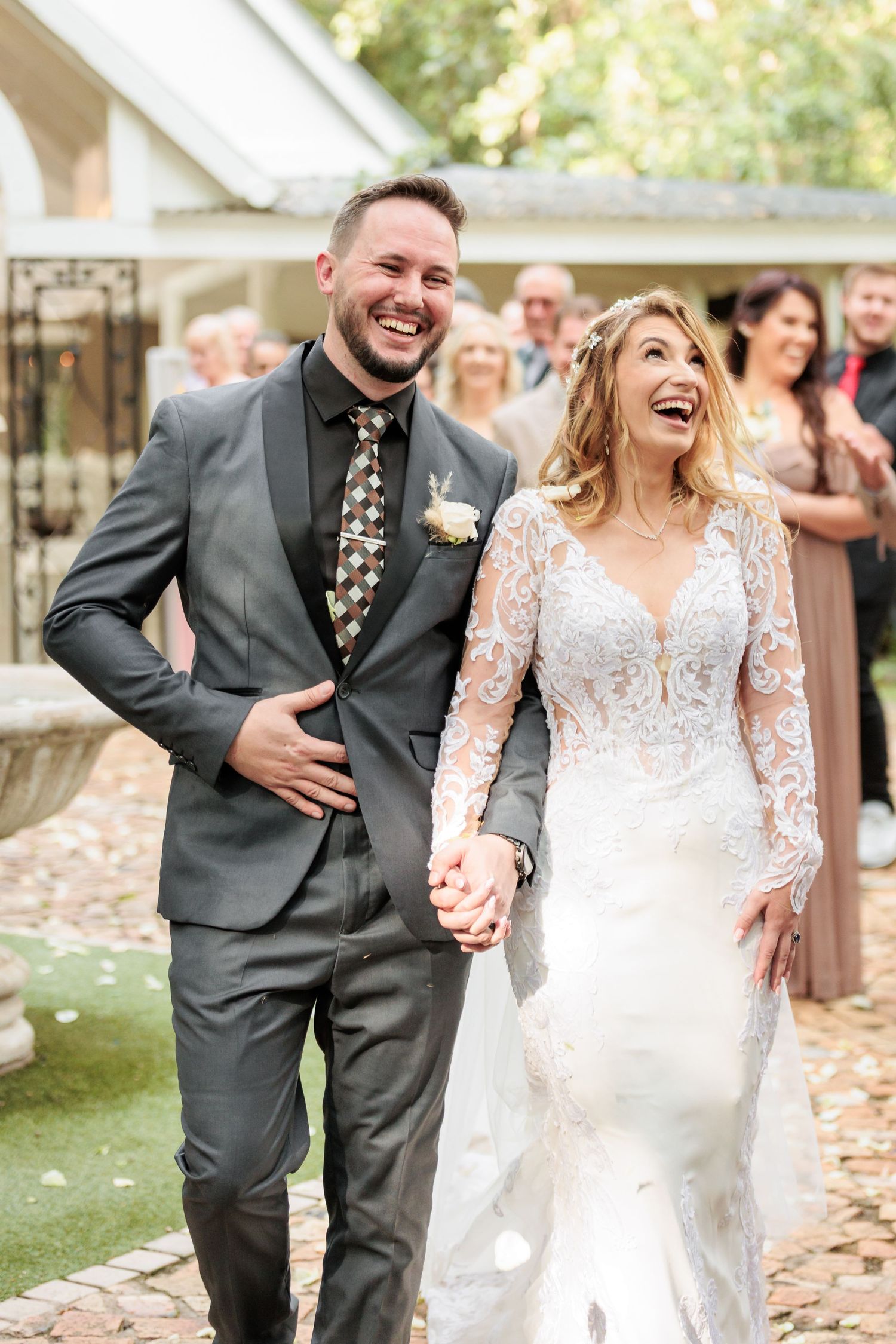 A happy couple shares joyful candid moments together during their outdoor autumn wedding celebration.