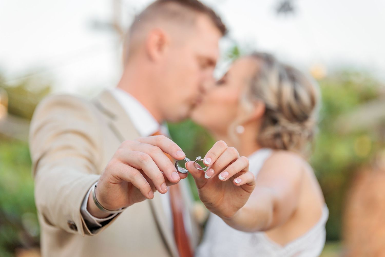 Joyful wedding couple sharing an intimate moment among vineyard rows.