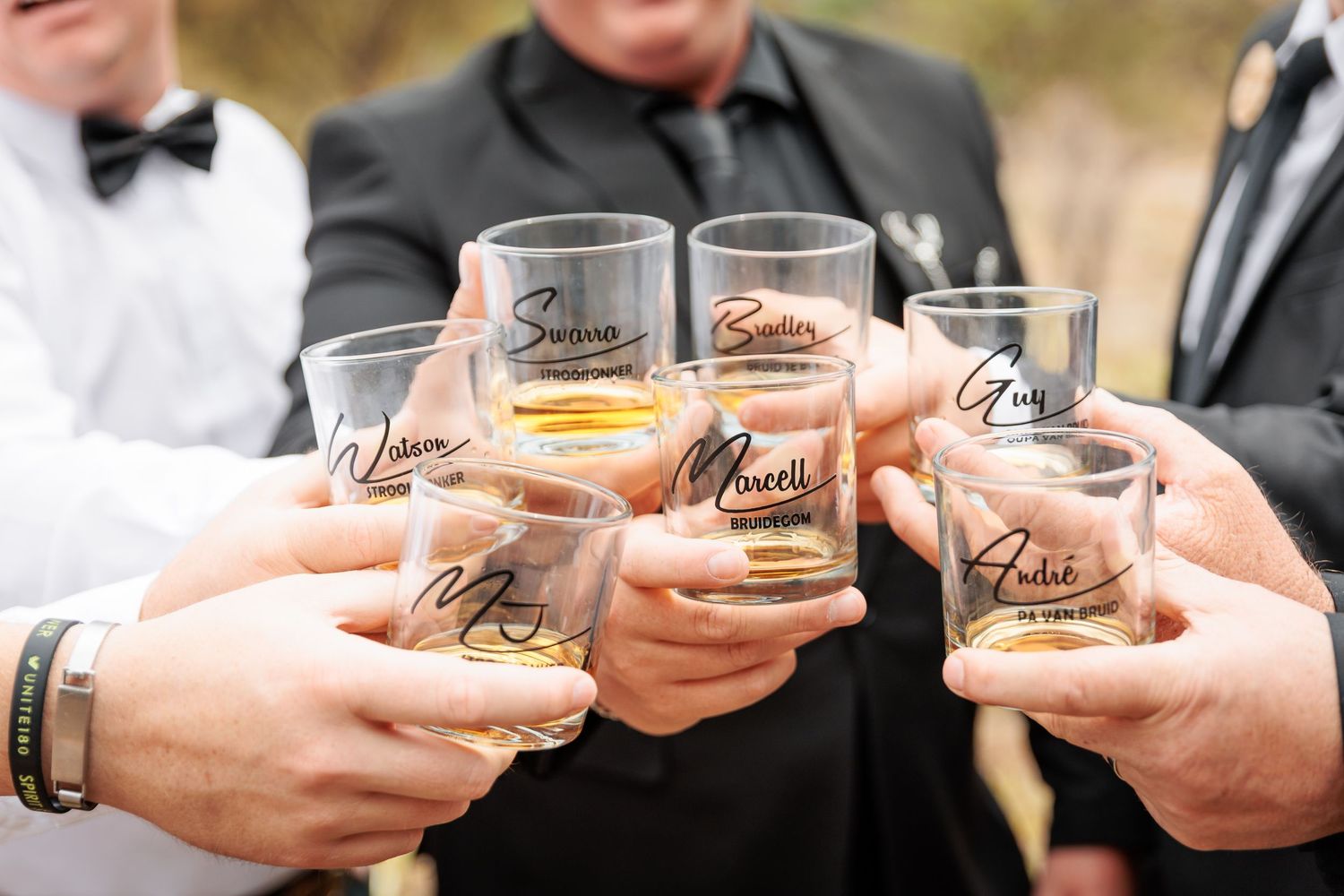 Wedding party members holding up shot glasses for a celebratory toast.