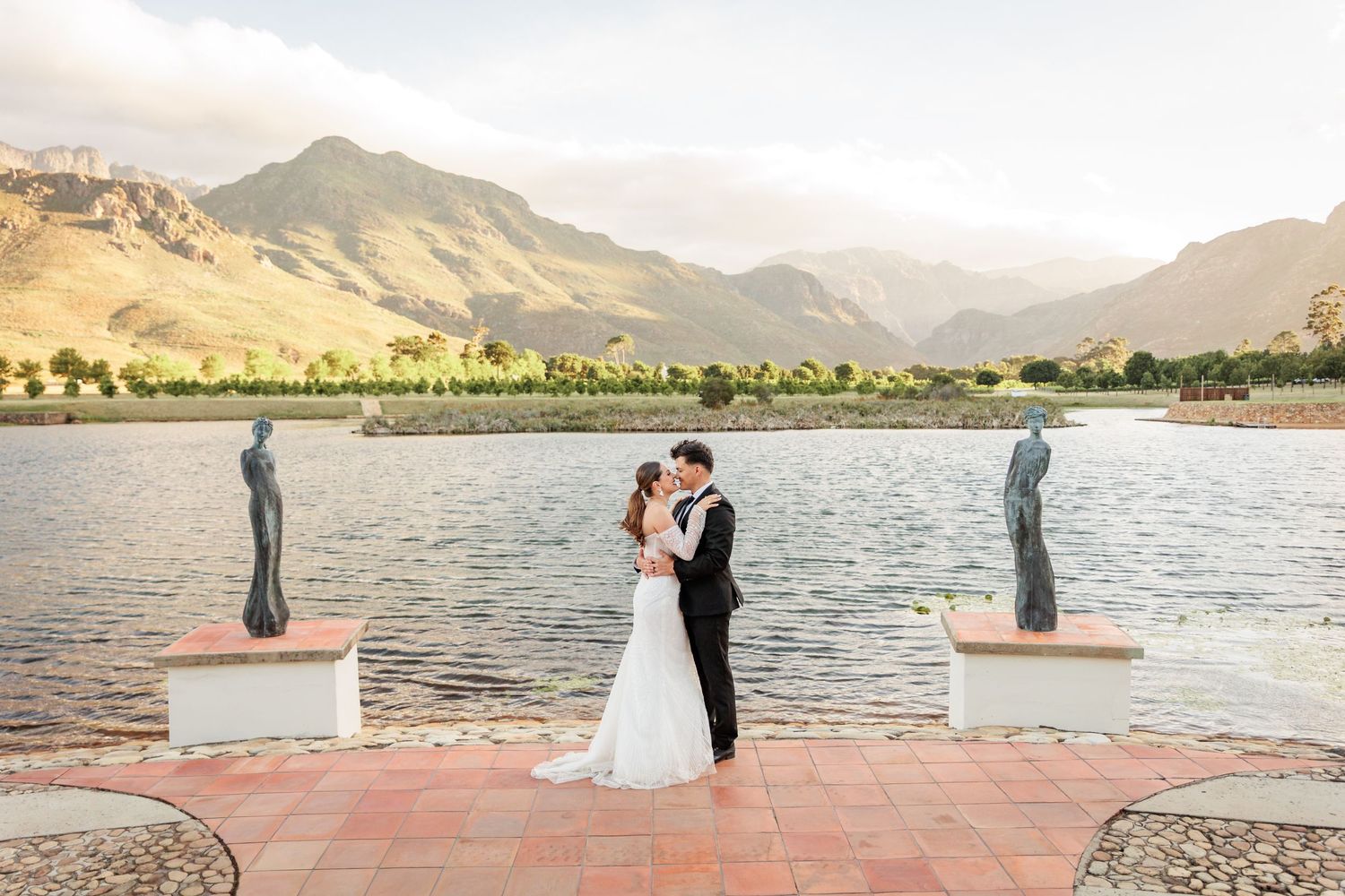 Scenic mountain landscape and lake views create a romantic backdrop for a wedding celebration at sunset.