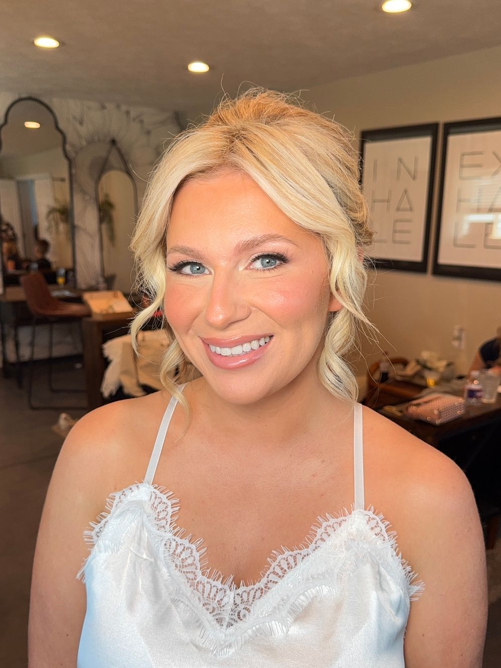 Glamour portrait with white lace top and professional makeup featuring winged eyeliner and pink lipstick.