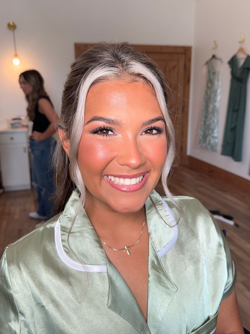 Candid smiling portraits in a mint green top against an interior backdrop with warm lighting.