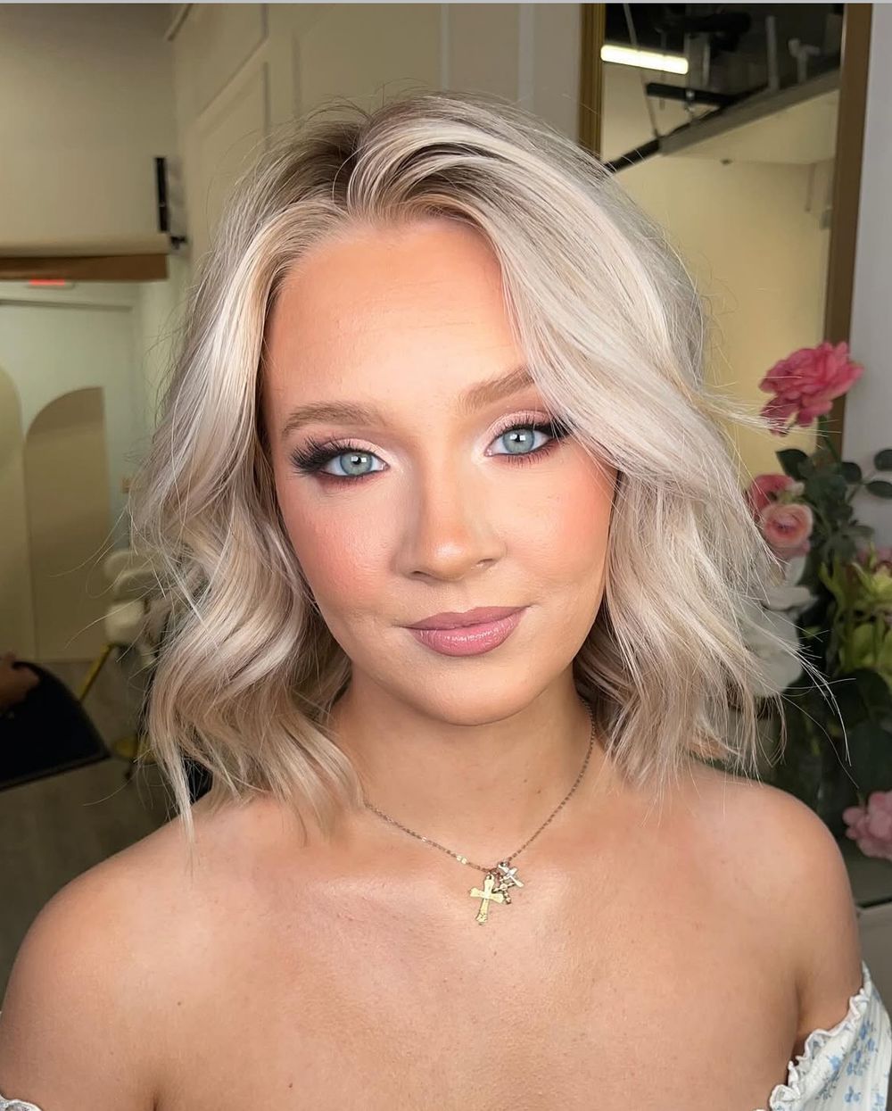 Glamorous bridal makeup look featuring platinum blonde hair, dramatic eye makeup and soft pink lips.