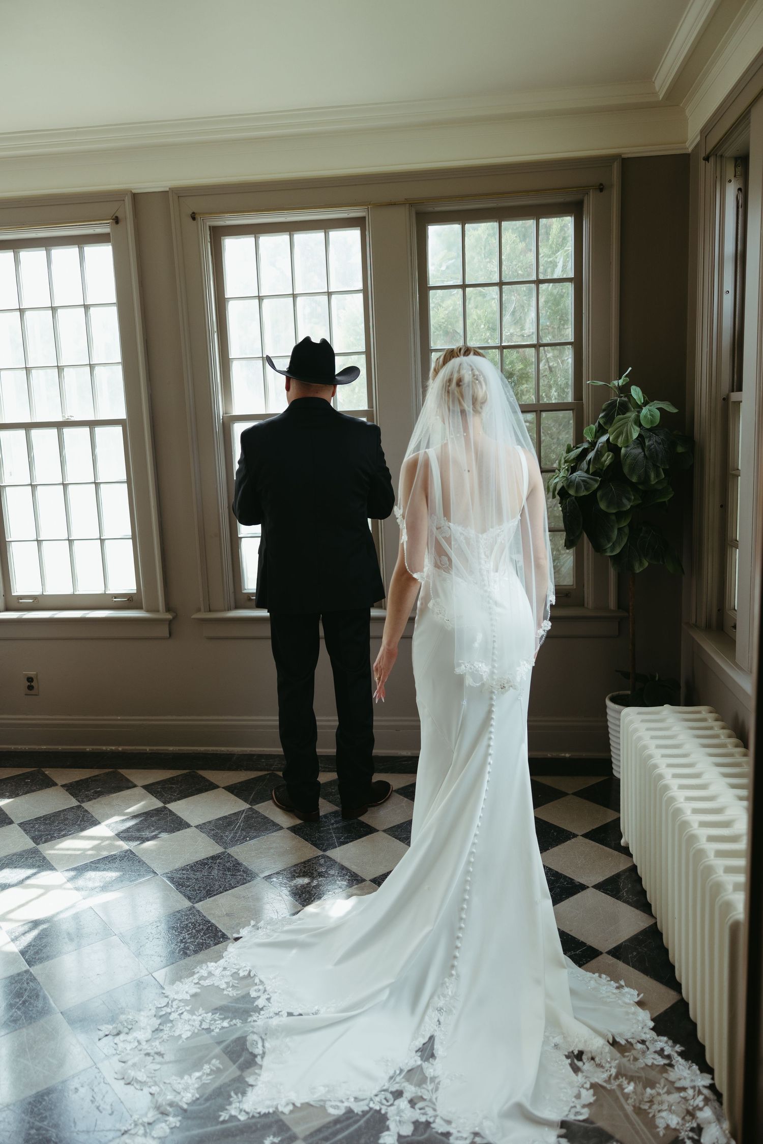 Wedding couple sharing a moment in an elegant room with checkered flooring.