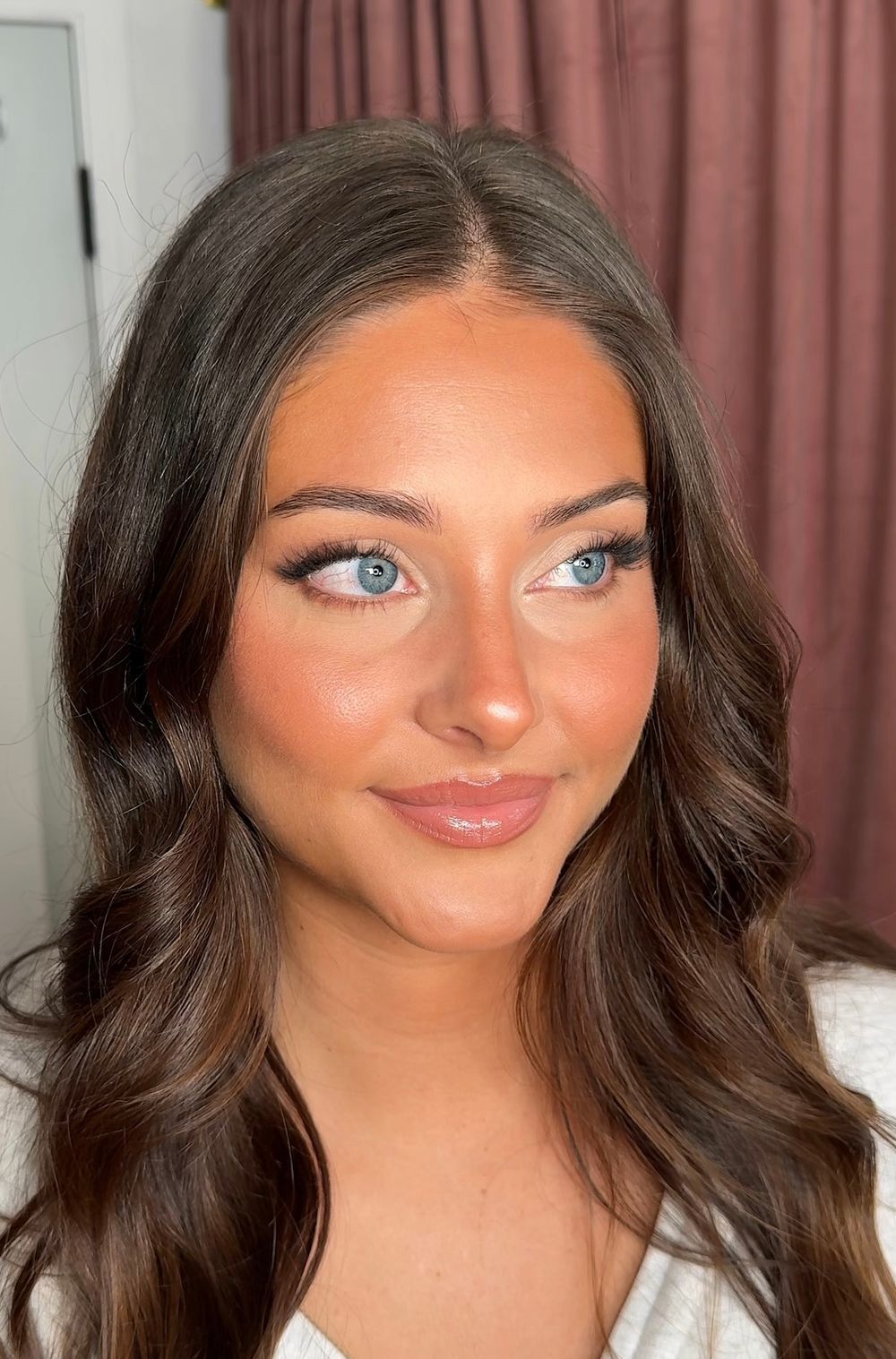 Close-up beauty shot showcasing glamorous wedding makeup and wavy dark hair.