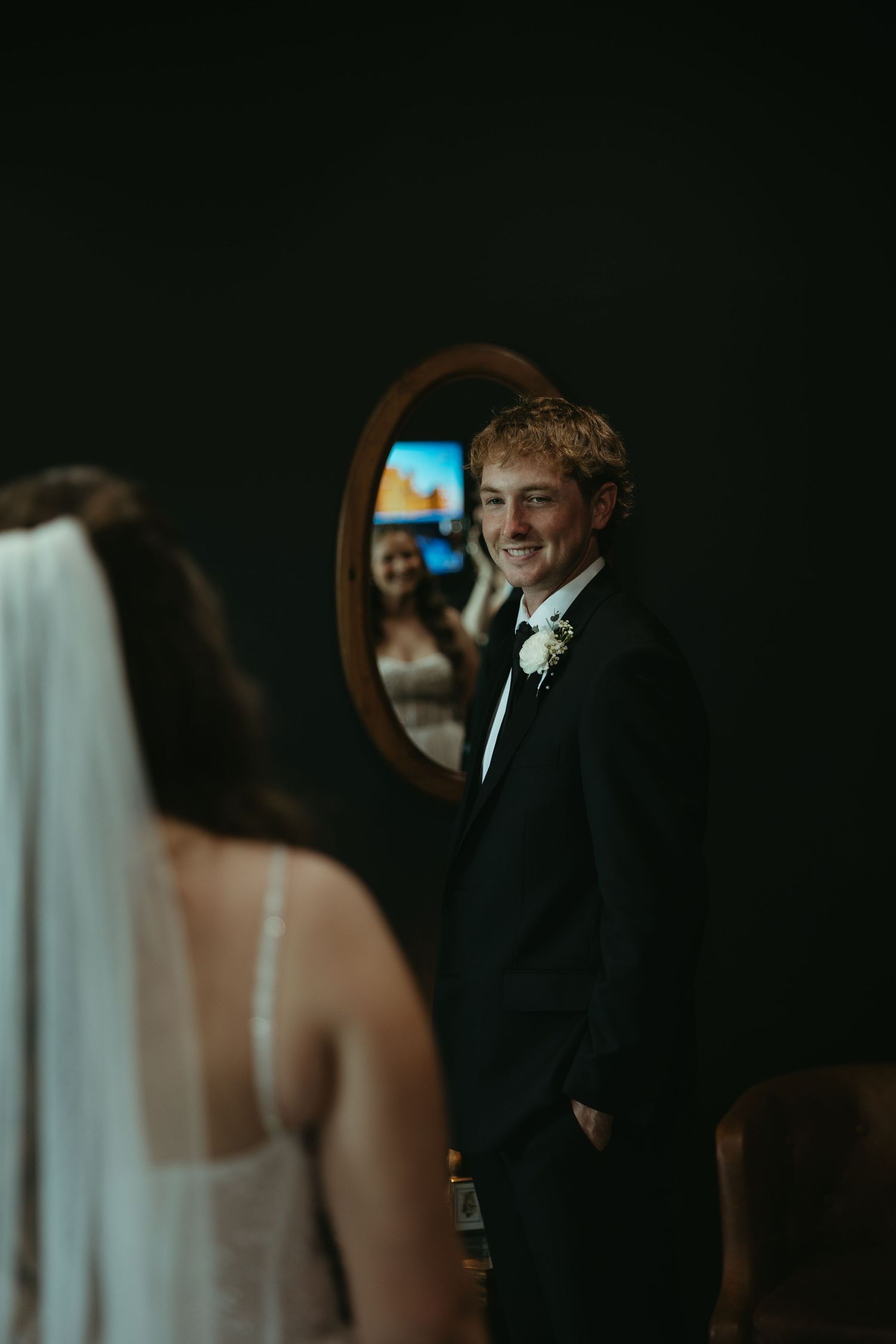 Couple shares an intimate moment in a dimly lit room during their wedding celebration.