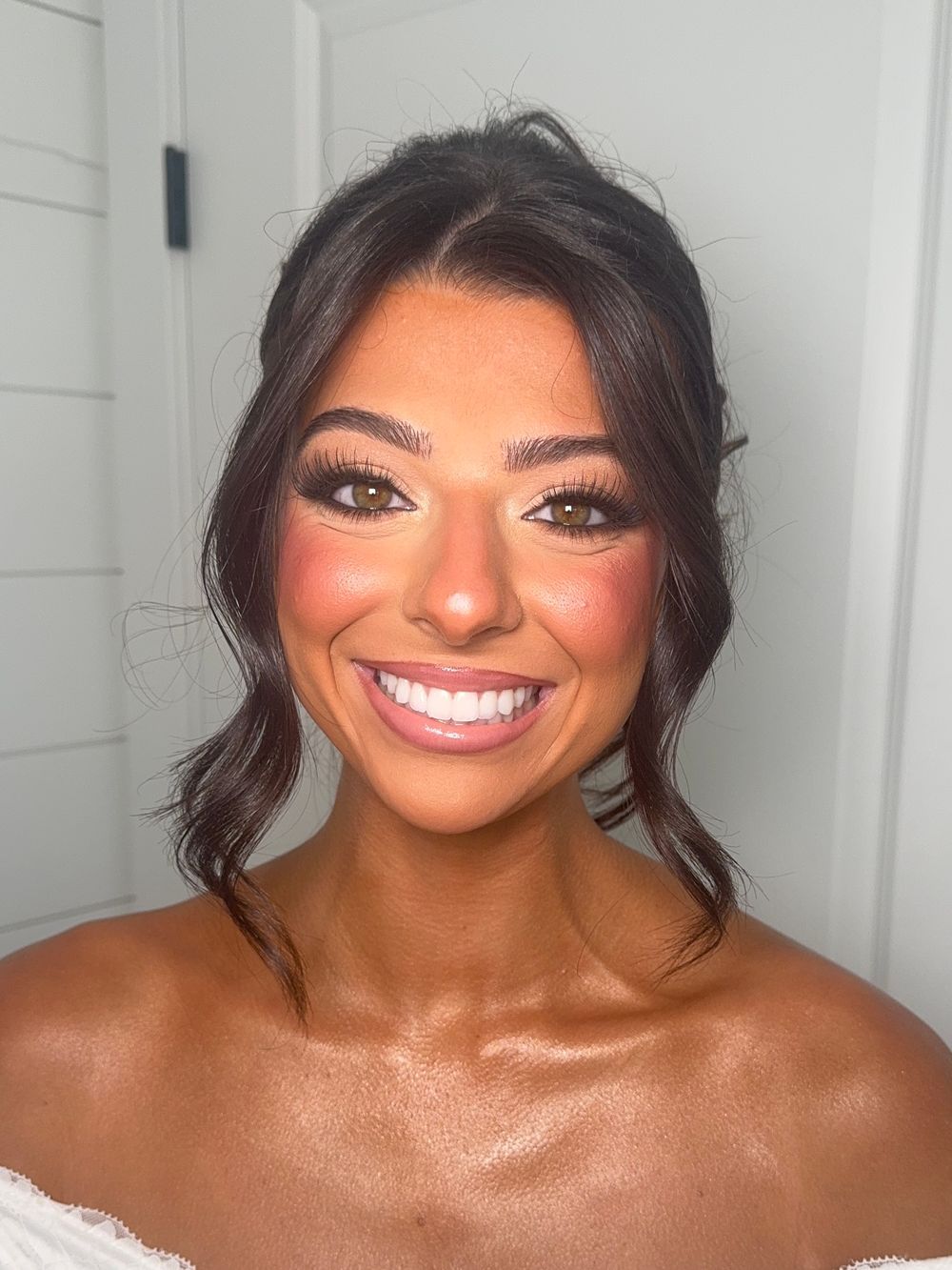 Series of bridal beauty shots showing glowing makeup and dark hair against white walls.