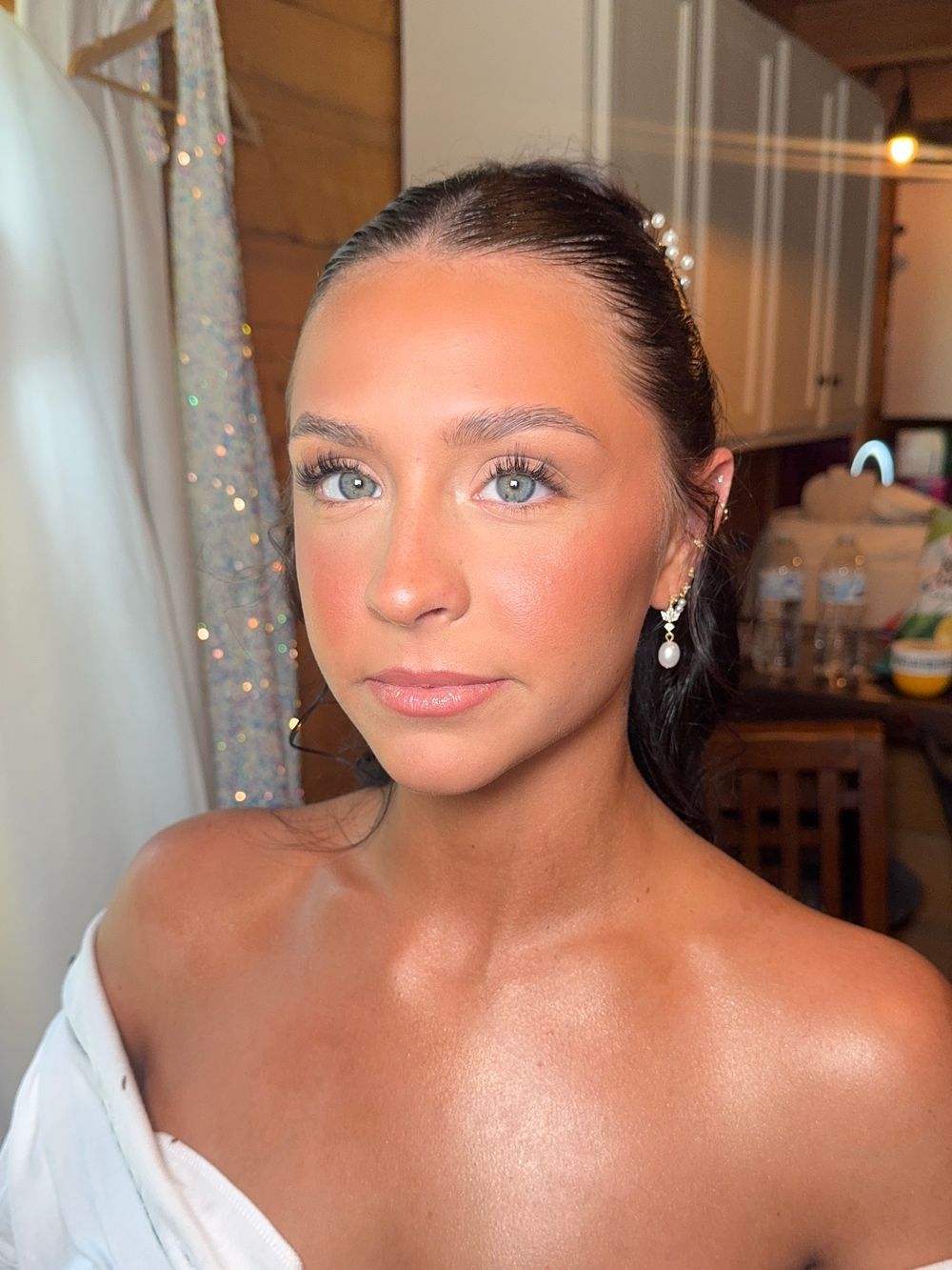 Elegant bridal portraits featuring upswept hair, crystal earrings and white dress.