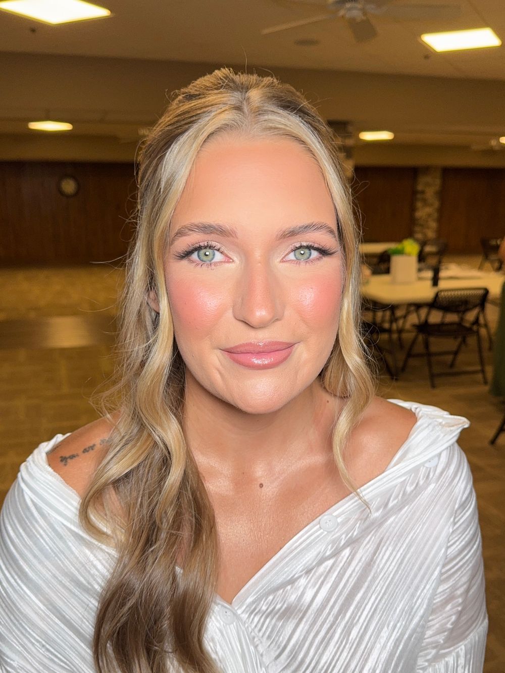 Casual glamour shots in a textured white top with soft waves and dramatic eye makeup.