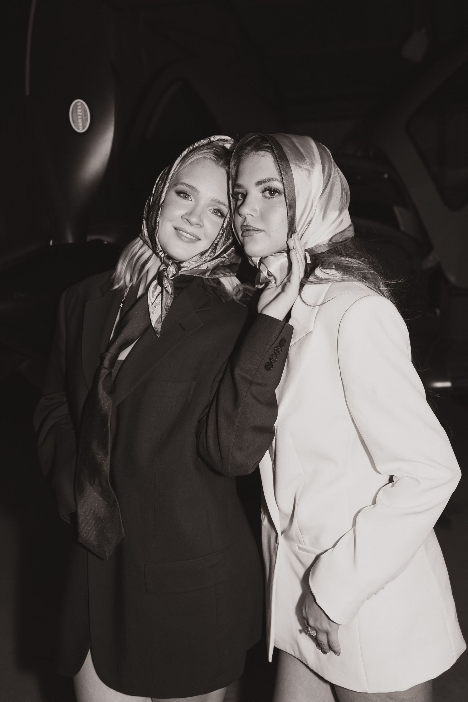 Black and white portrait of two people in contrasting hoodies.