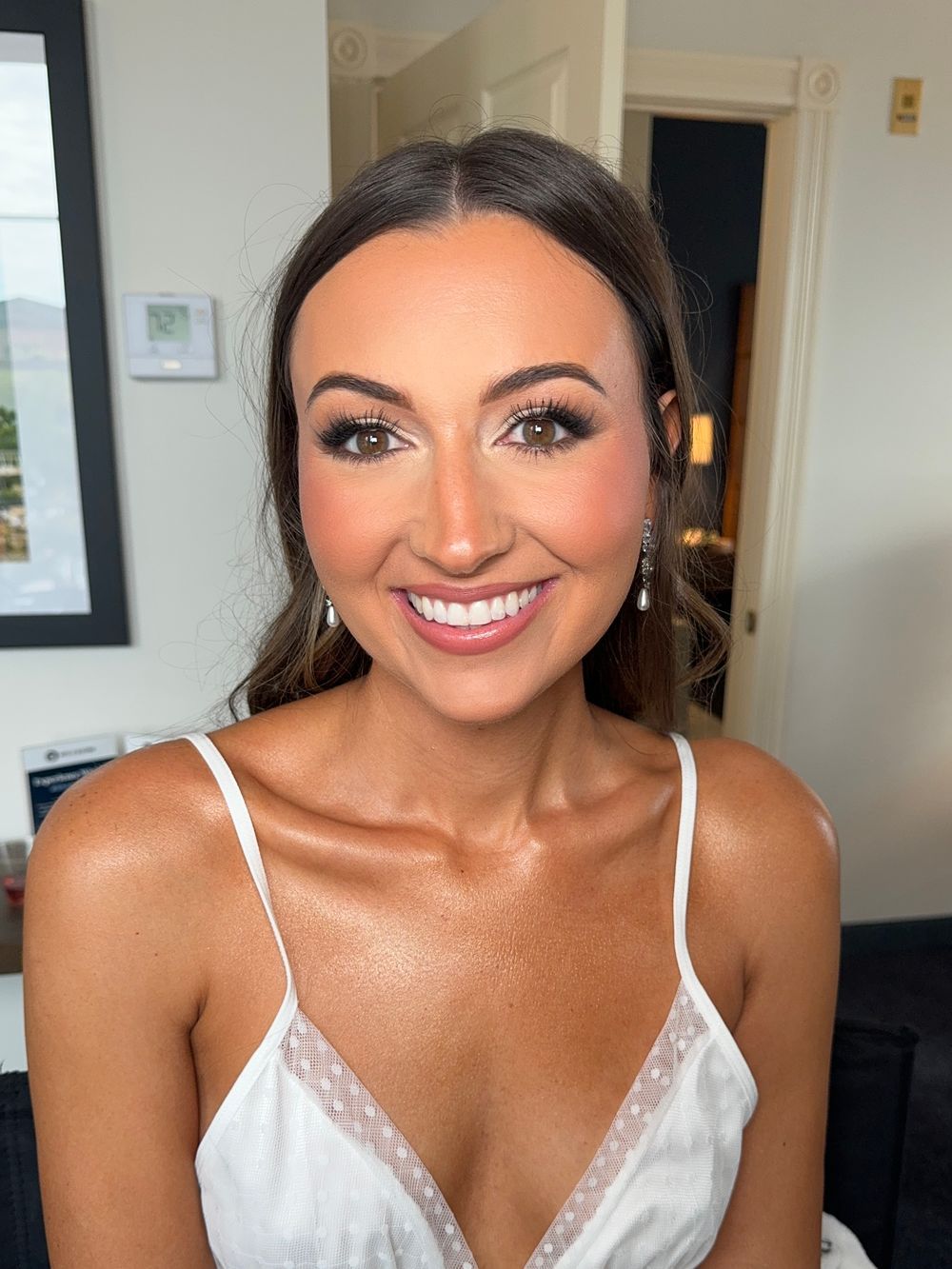 Candid bridal portrait showing radiant makeup and white lace details.