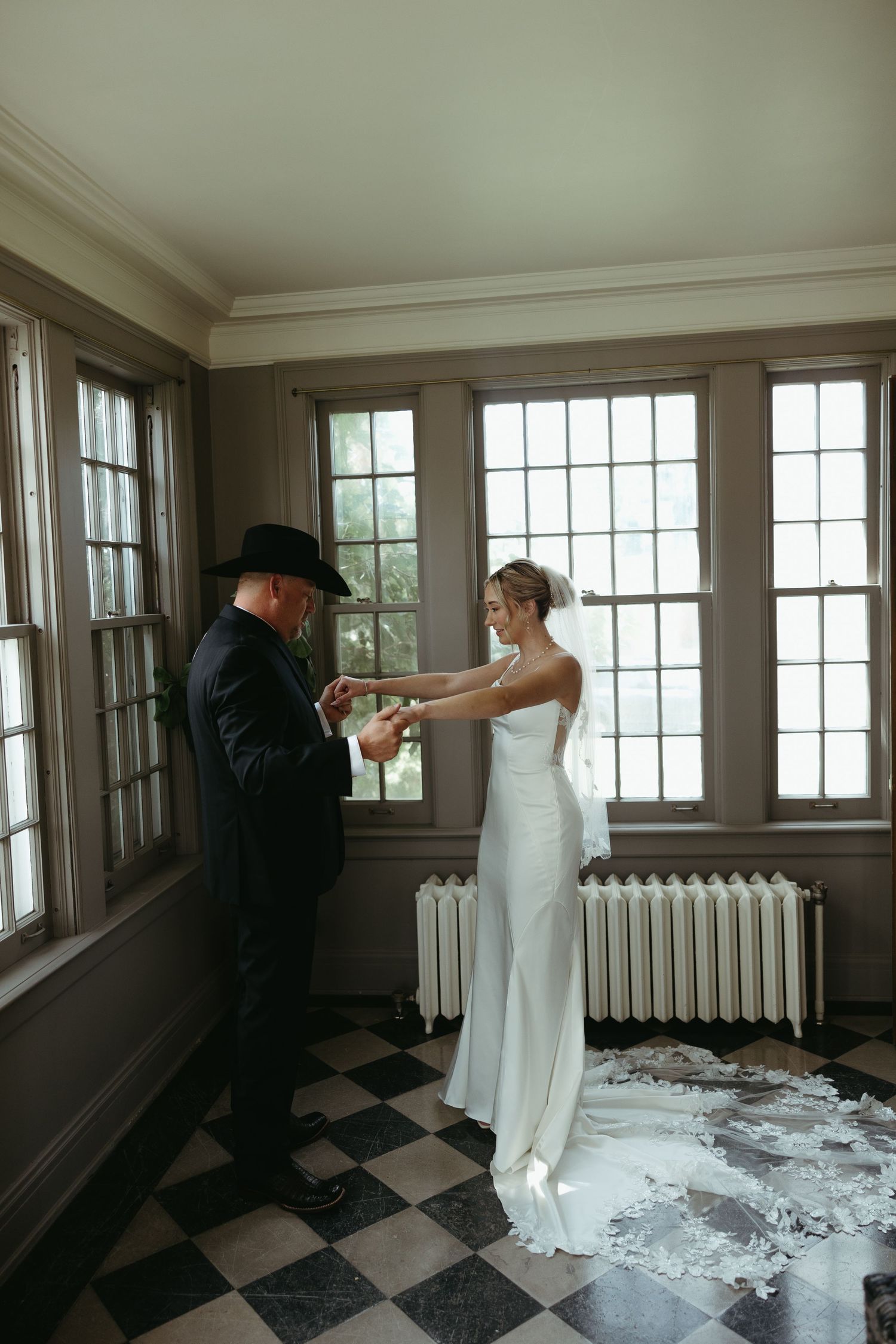 First look moment captured in a room with checkered floors and large windows.