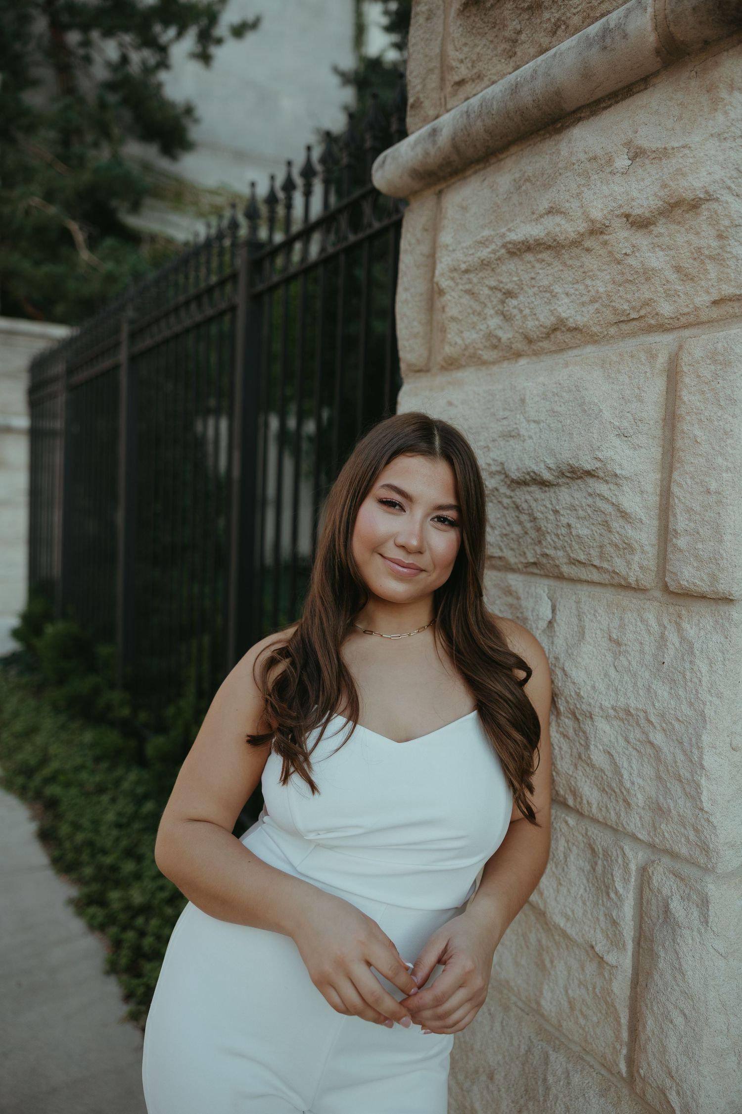 Portrait series against a stone wall featuring soft natural lighting.