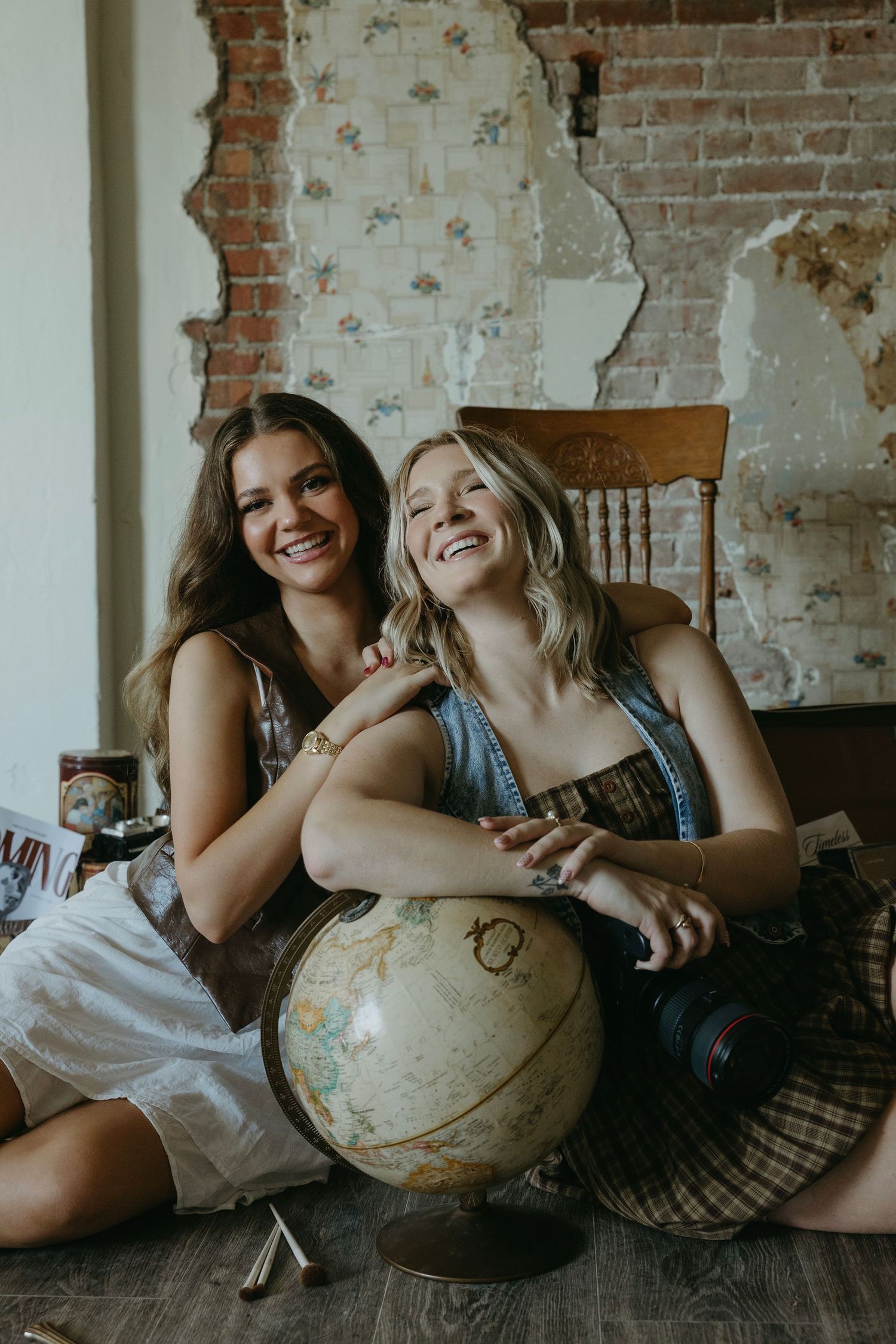 Candid lifestyle photos with vintage globe props against rustic brick wall backdrop.