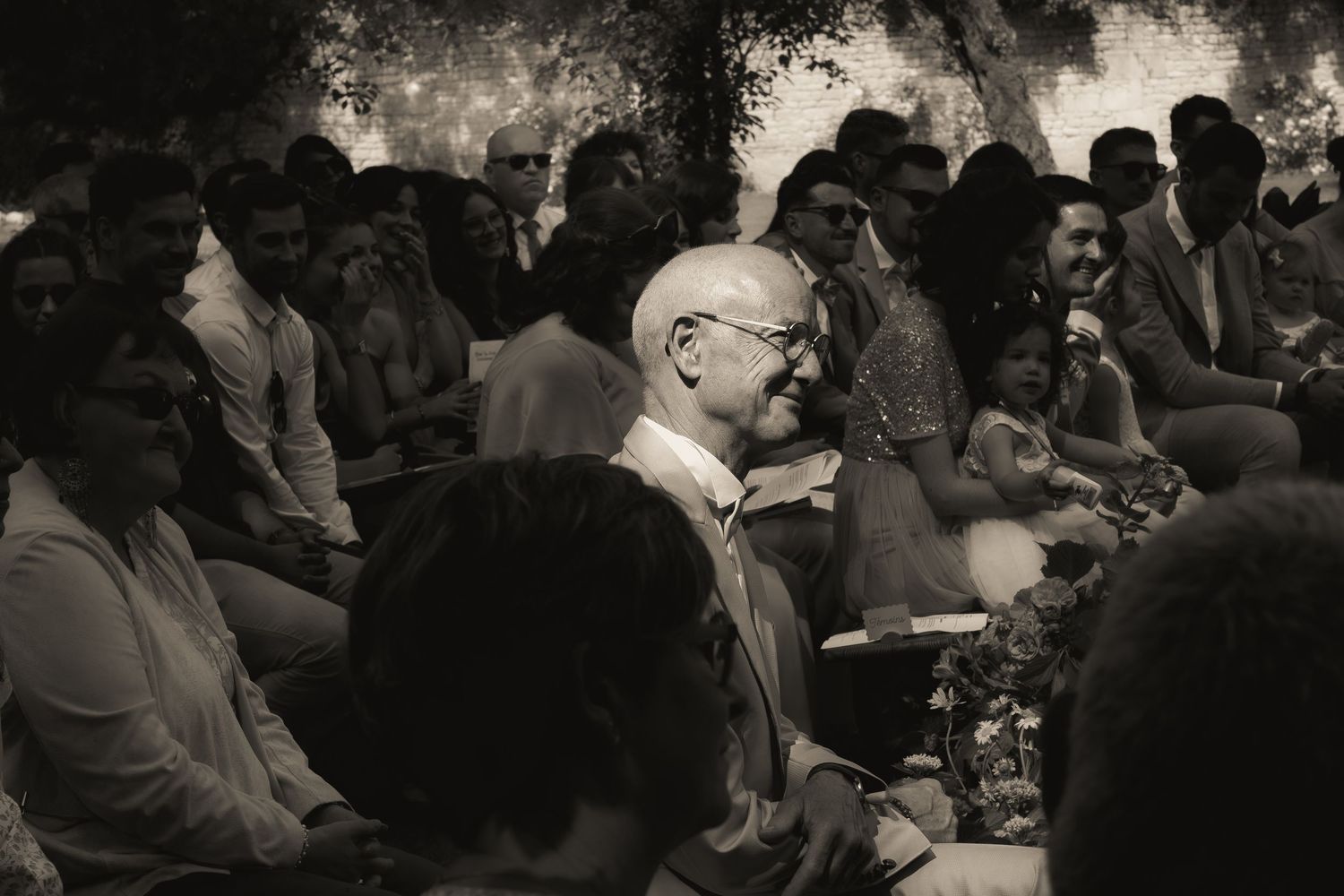 Black and white portrait of the groom's father during an emotional wedding ceremony