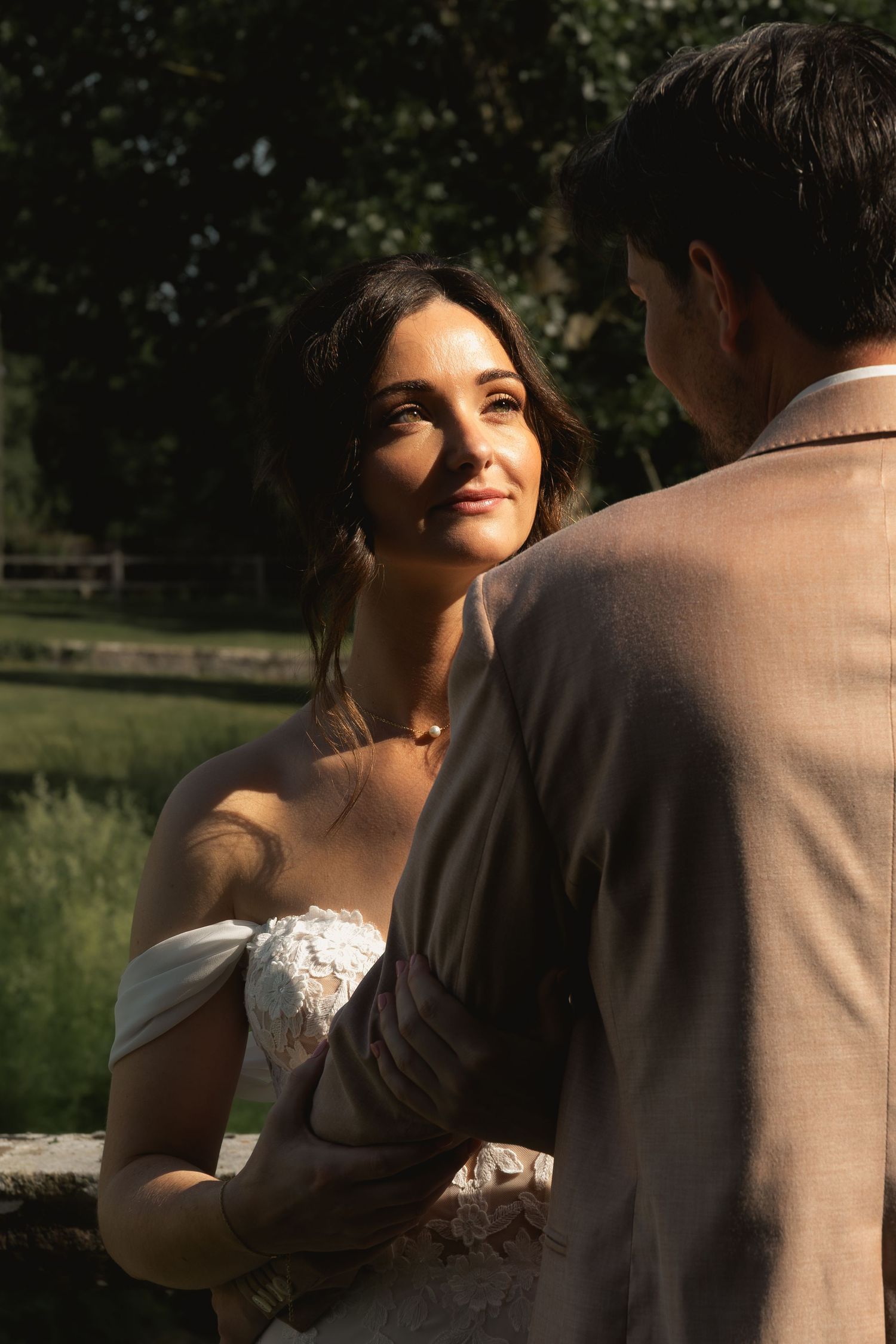 Bride looking at the groom during golden hour with sunlight reflecting in her eyes