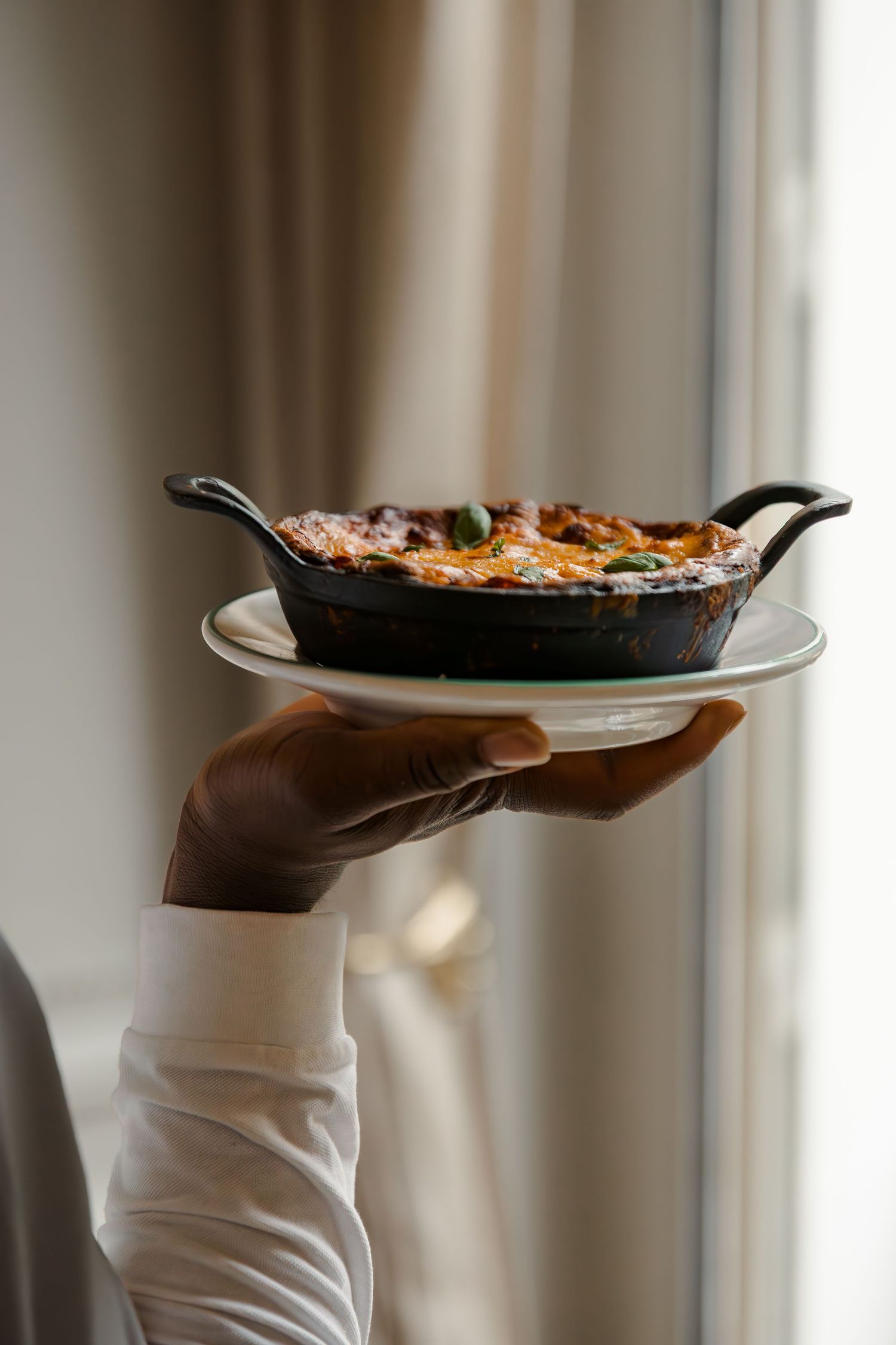 Server bringing homemade lasagna to a table at Casetta restaurant in Hôtel 5 Particulier, Neuilly