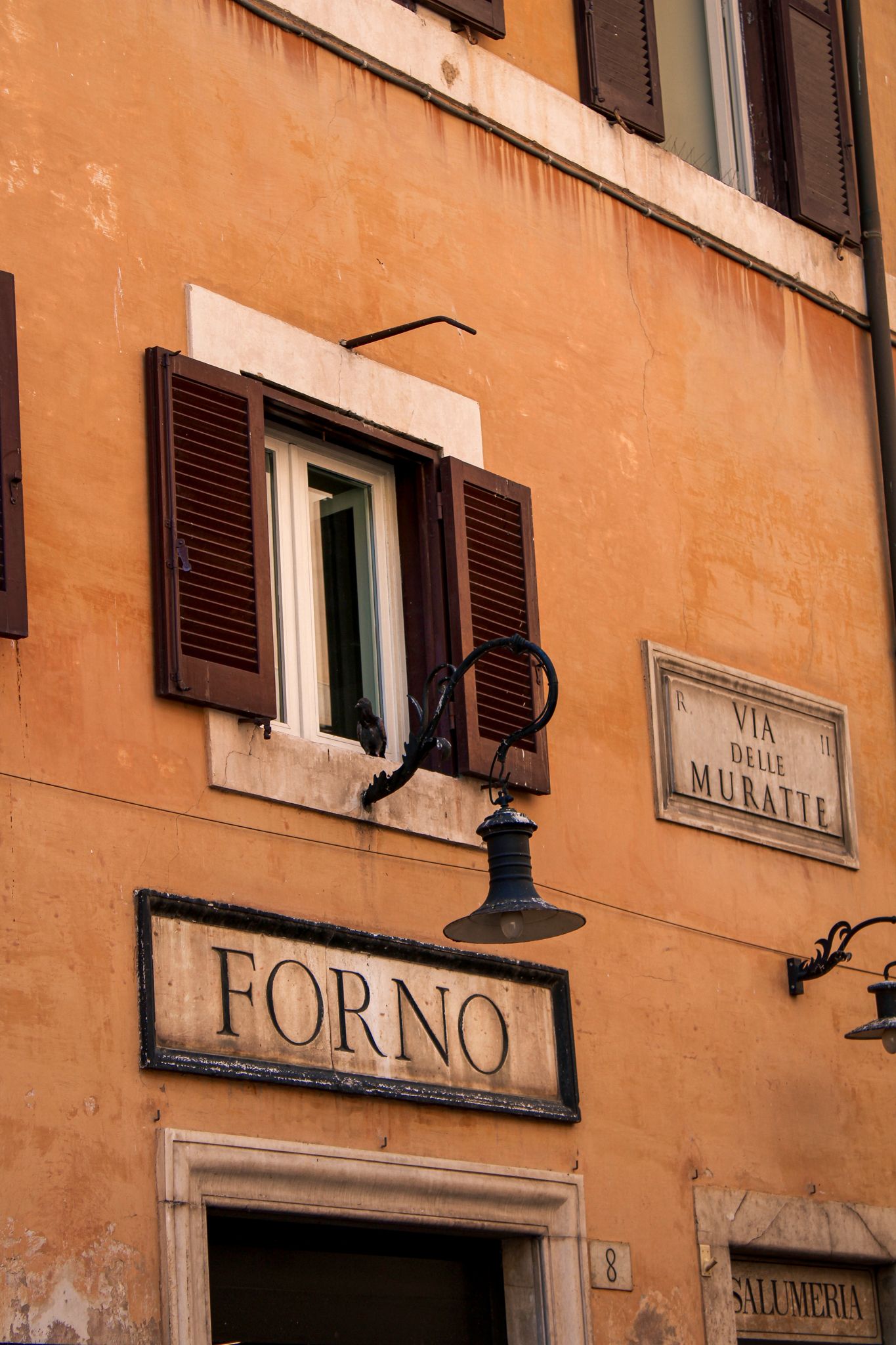 Yellow building facade with the Forno bakery storefront in Rome