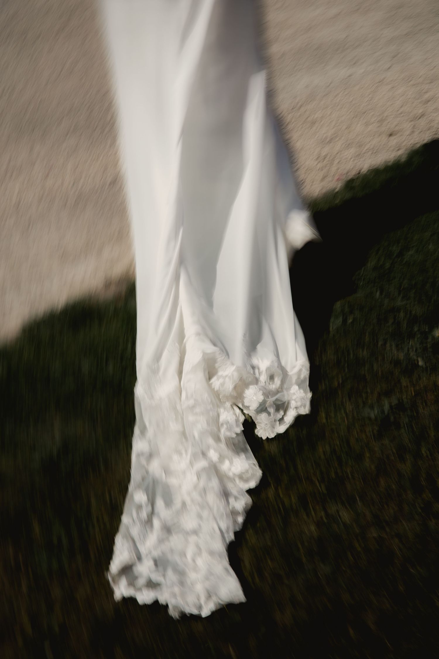 Bride's wedding dress train flowing in motion as she walks, captured in an elegant editorial style.