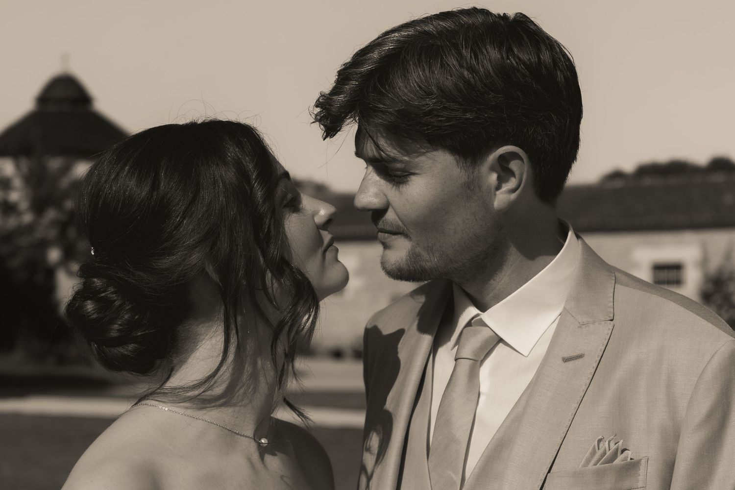 Intimate black and white close-up portrait of a bride and groom gazing at each other before a kiss