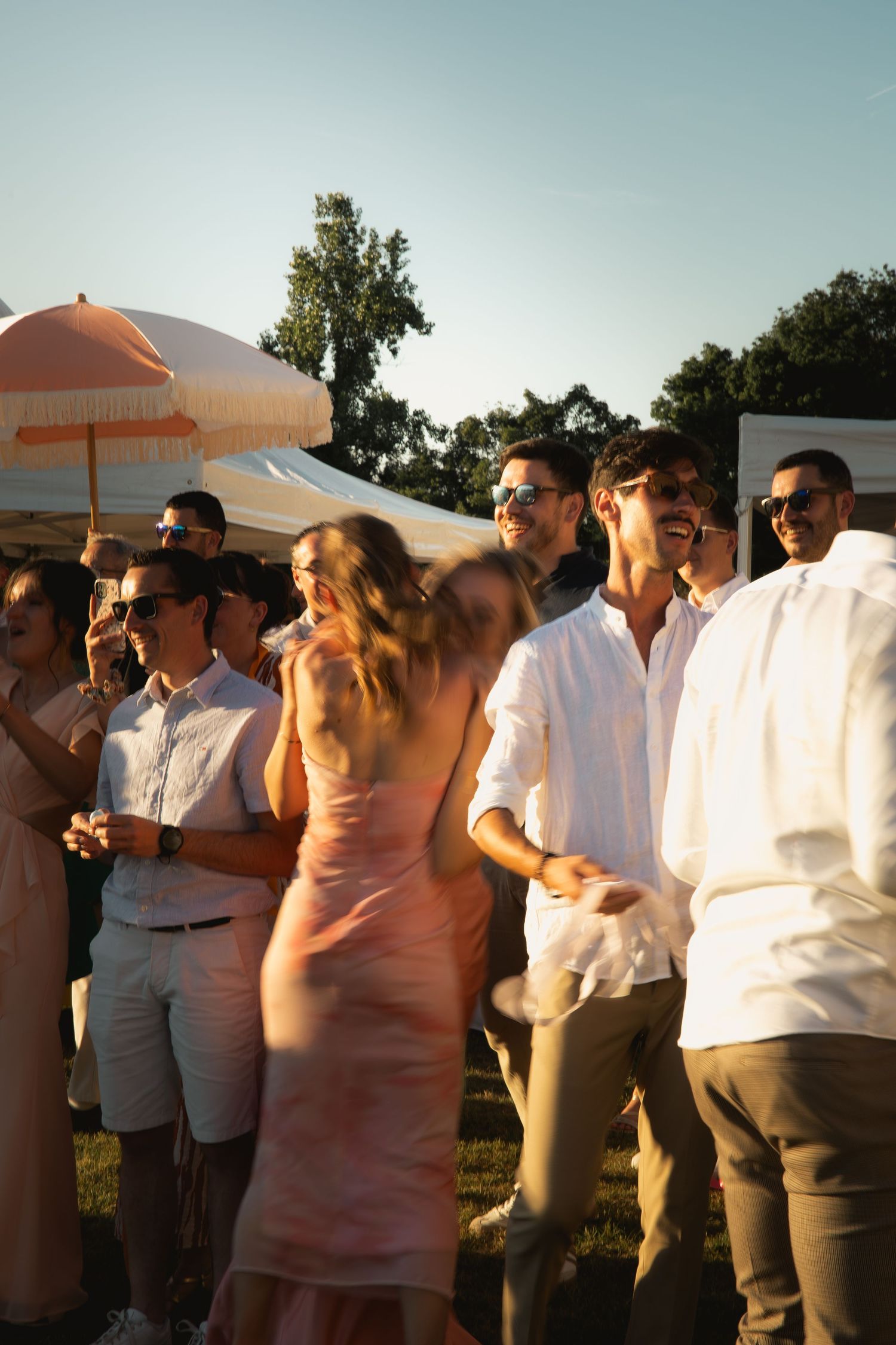 Wedding guests enjoying a summer evening celebration outdoors during golden hour