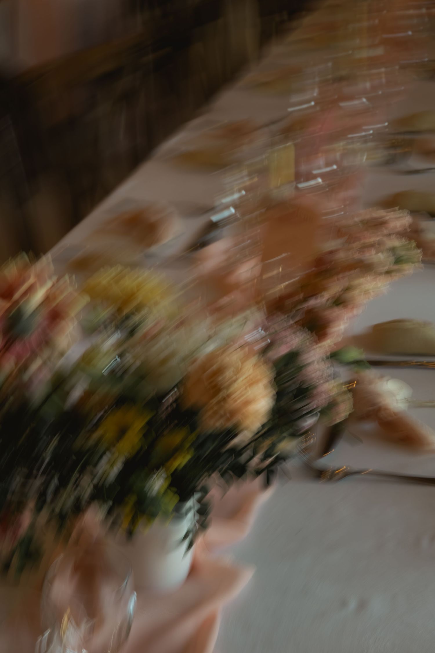 Artistic wedding table setting captured with intentional motion blur for an editorial and atmospheric feel.