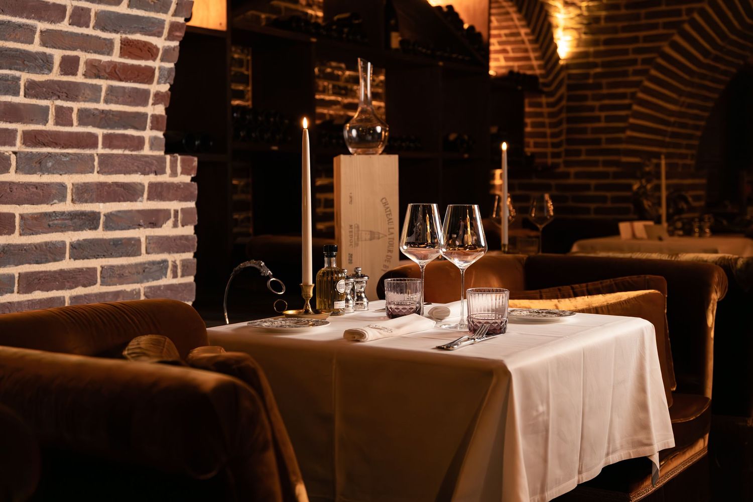 Elegant dining room beneath vaulted ceilings at Félicie restaurant, Maison Maubreuil, with a candlelit table