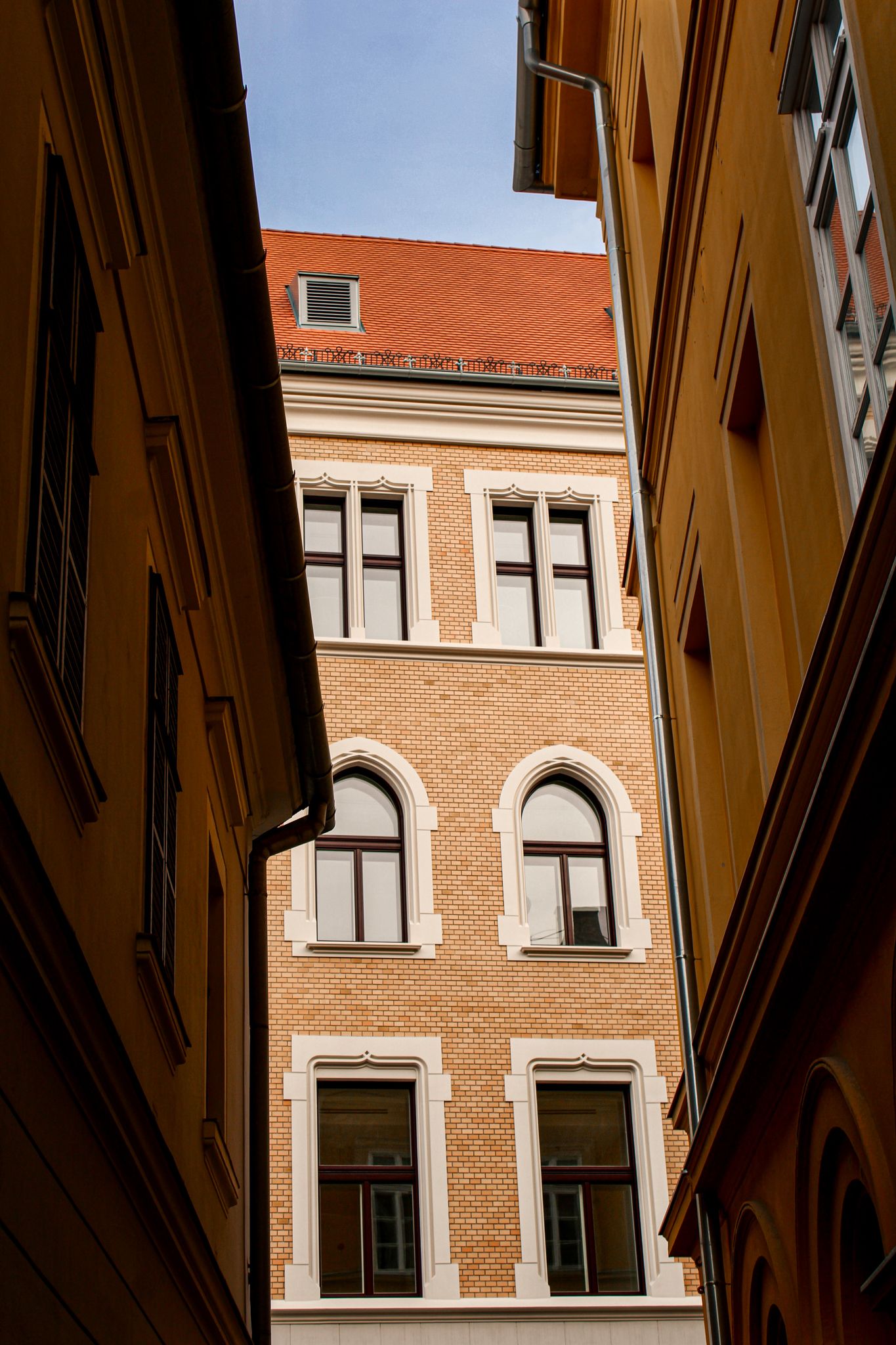 Low-angle view of a yellow historic building and architectural lines in a Budapest street