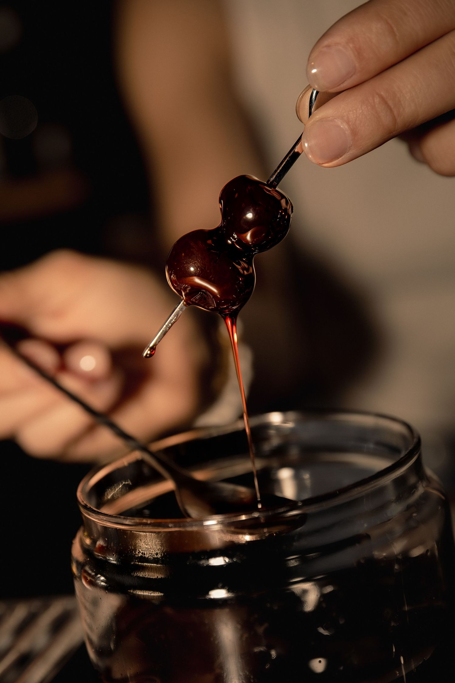 Bartender preparing a homemade cocktail with cherries at Le Distrait bar in Paris