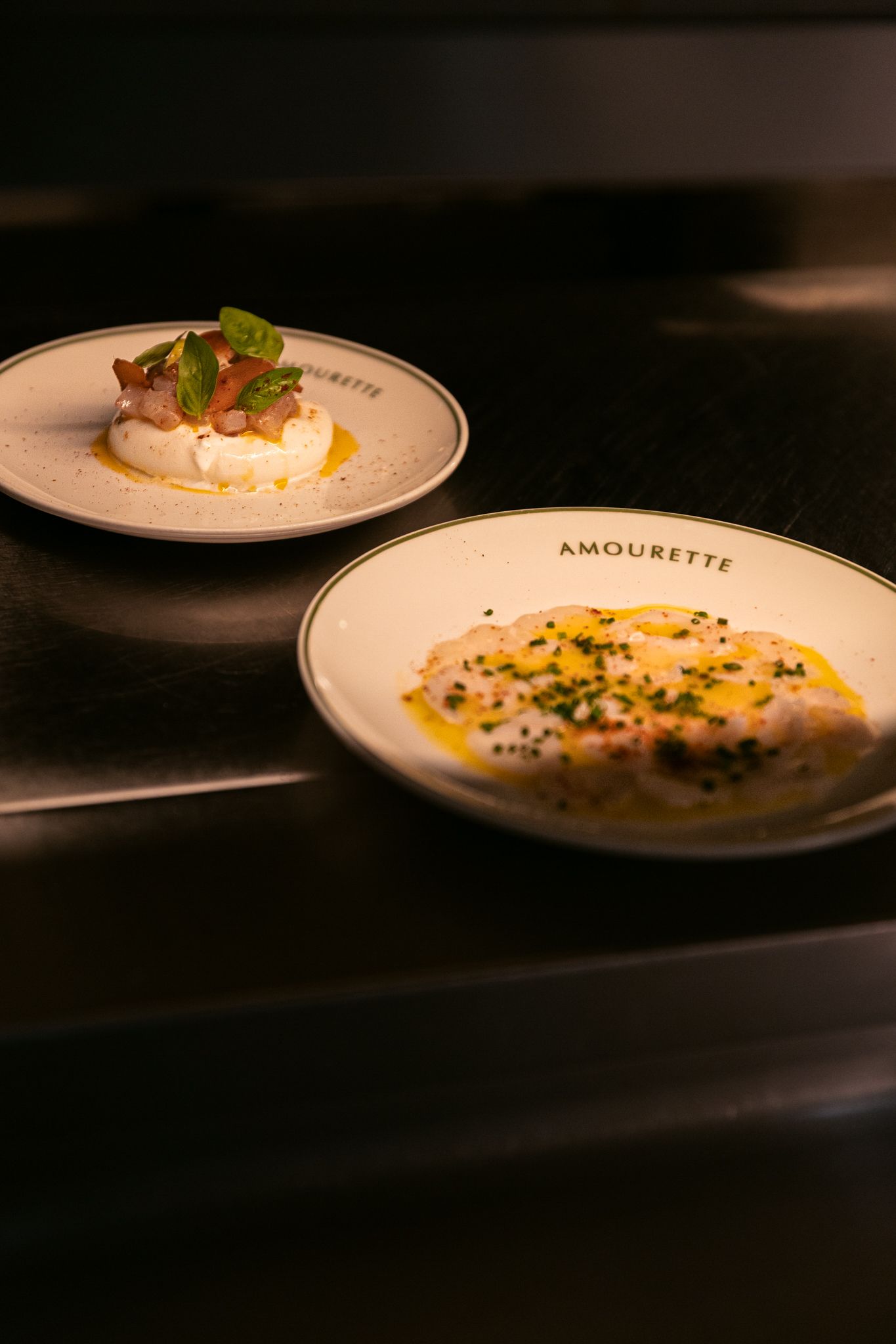Chef preparing refined dishes including sea bass tartare, burrata and bottarga at Amourette restaurant in Paris