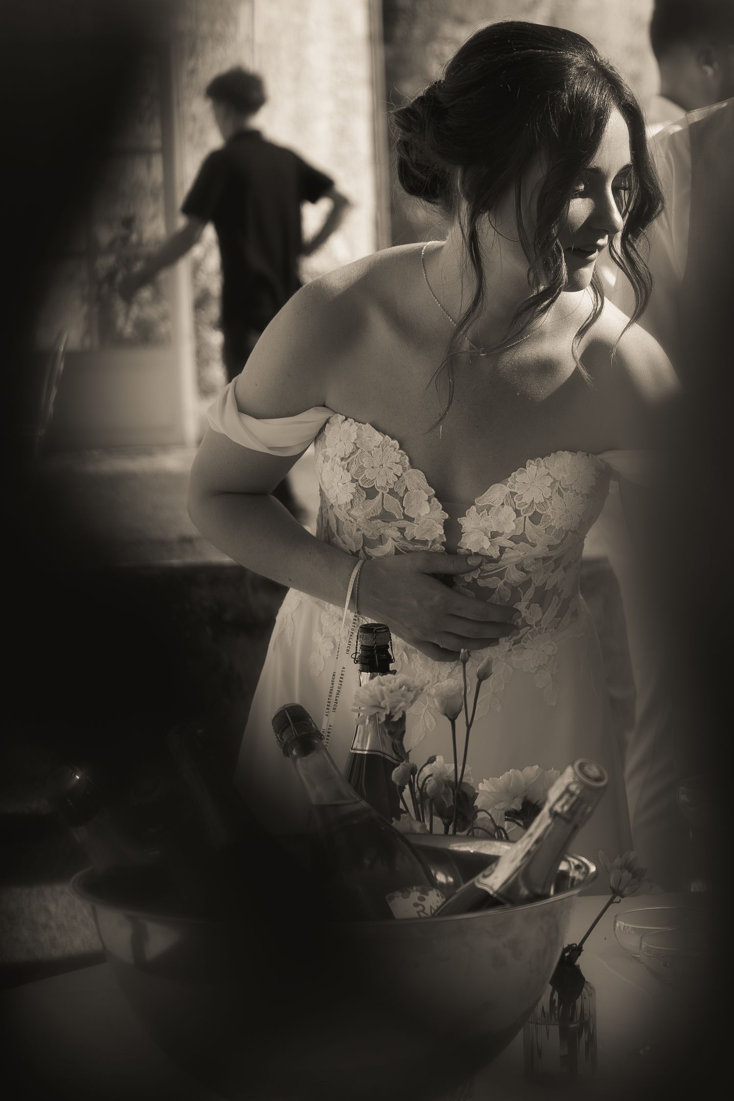 Black and white portrait of the bride beside a champagne tower during the wedding reception