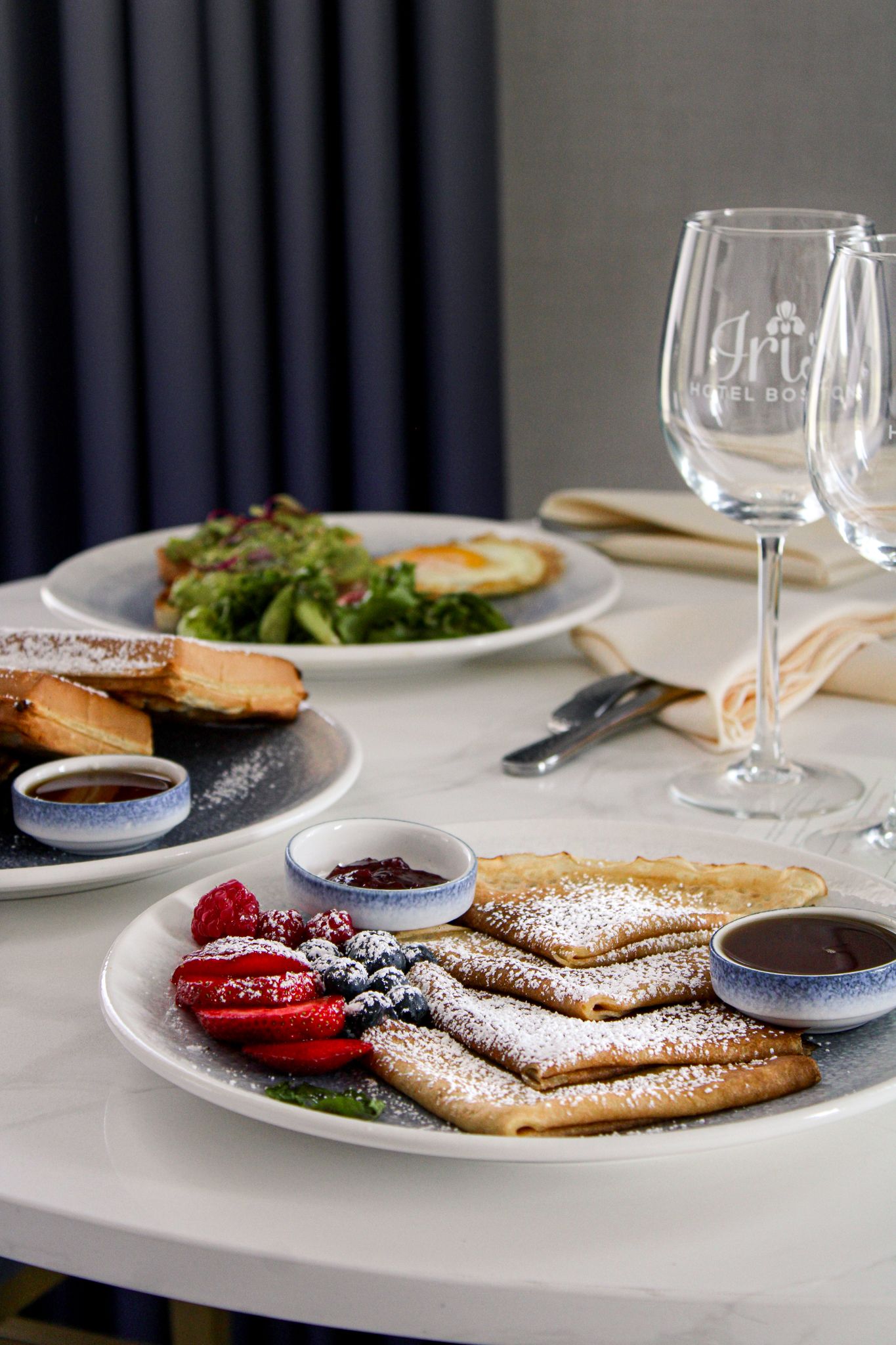 In-room breakfast served in a luxury suite at Iris Hotel Boston with pancakes, waffles, avocado toast, eggs and fresh fruit