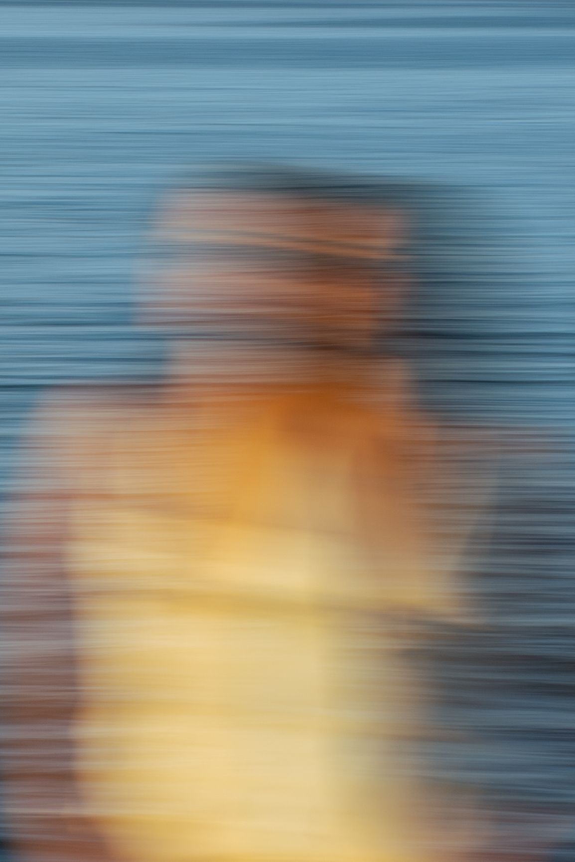 Portrait of a woman in movement on the beach in warm natural light, with ocean and soft tones creating a cinematic mood.
