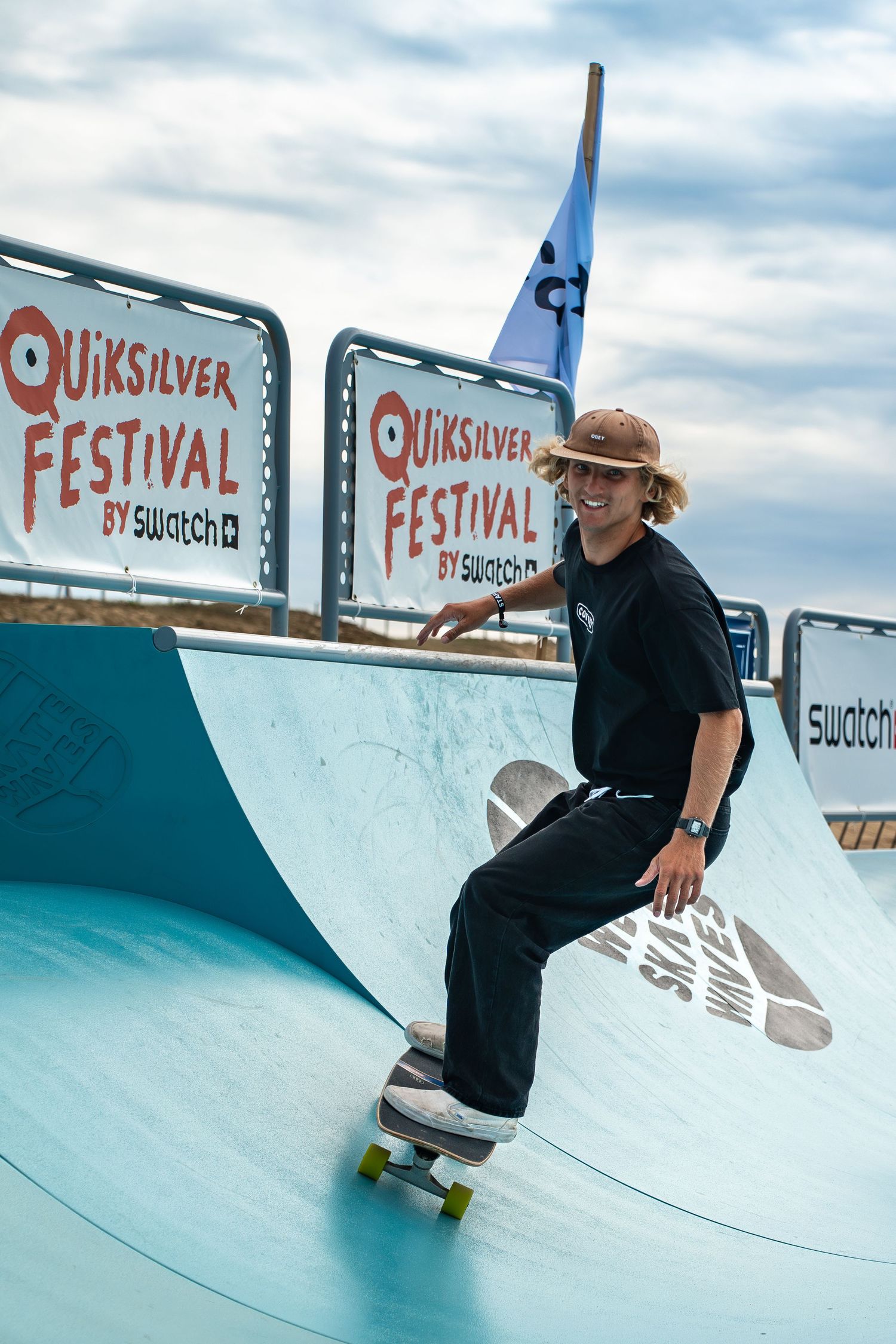 Skateboard competition on the beach, athletes performing tricks with ocean in the background, dynamic movement and vibrant summer atmosphere