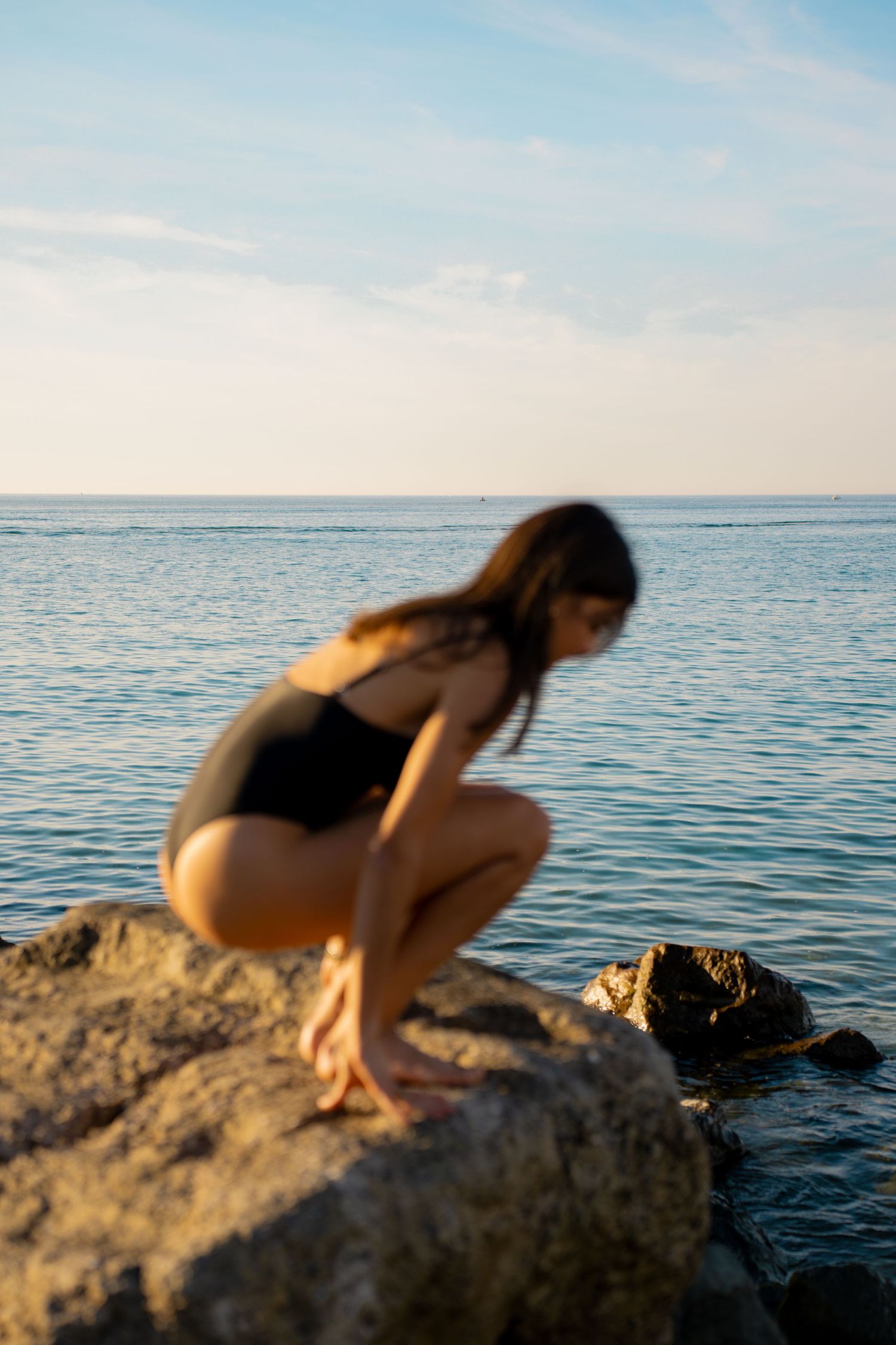 Portrait of a woman on the beach in warm natural light, with ocean and soft tones creating a cinematic mood.
