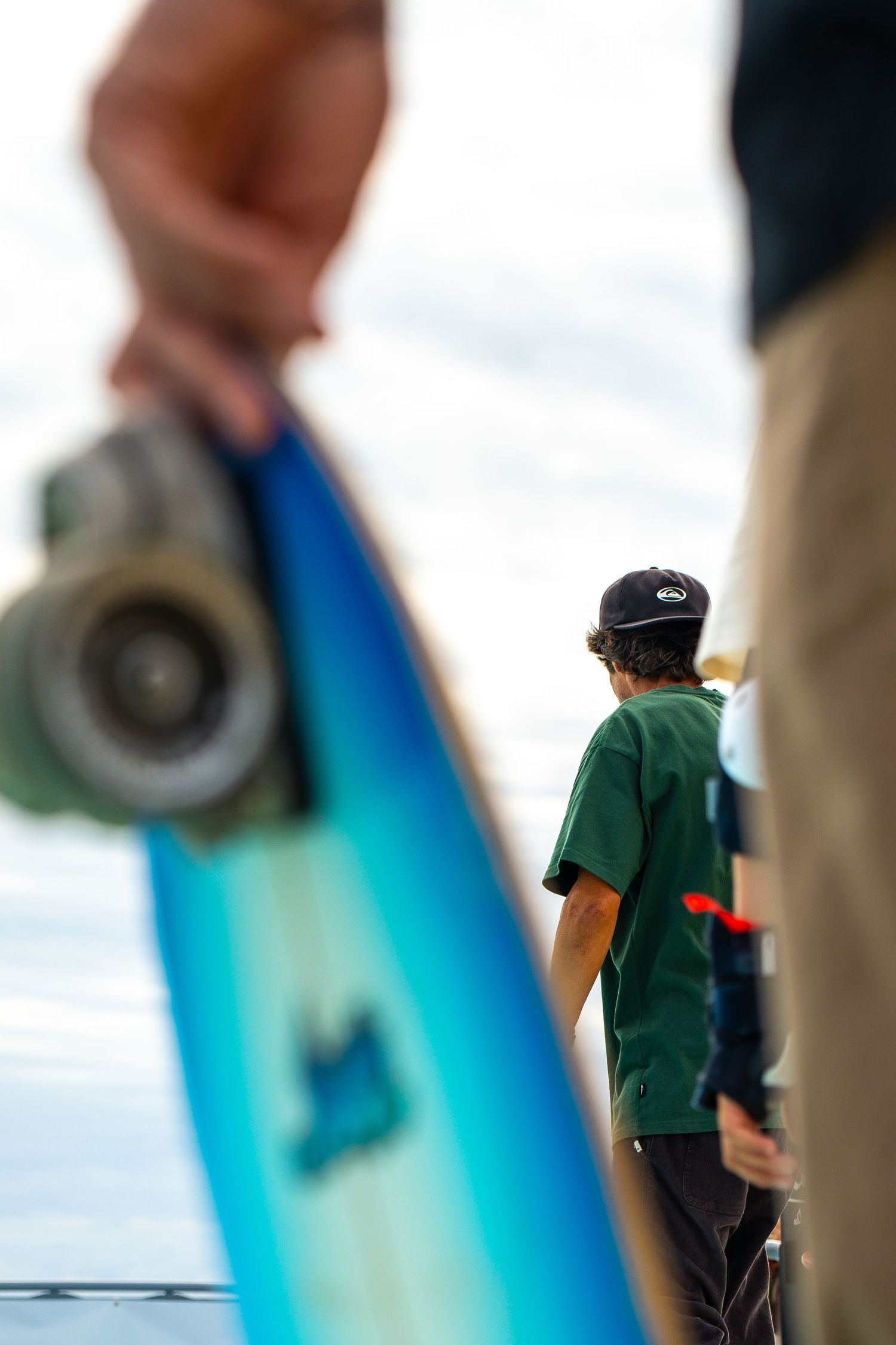 Skateboard competition on the beach, athletes performing tricks with ocean in the background, dynamic movement and vibrant summer atmosphere