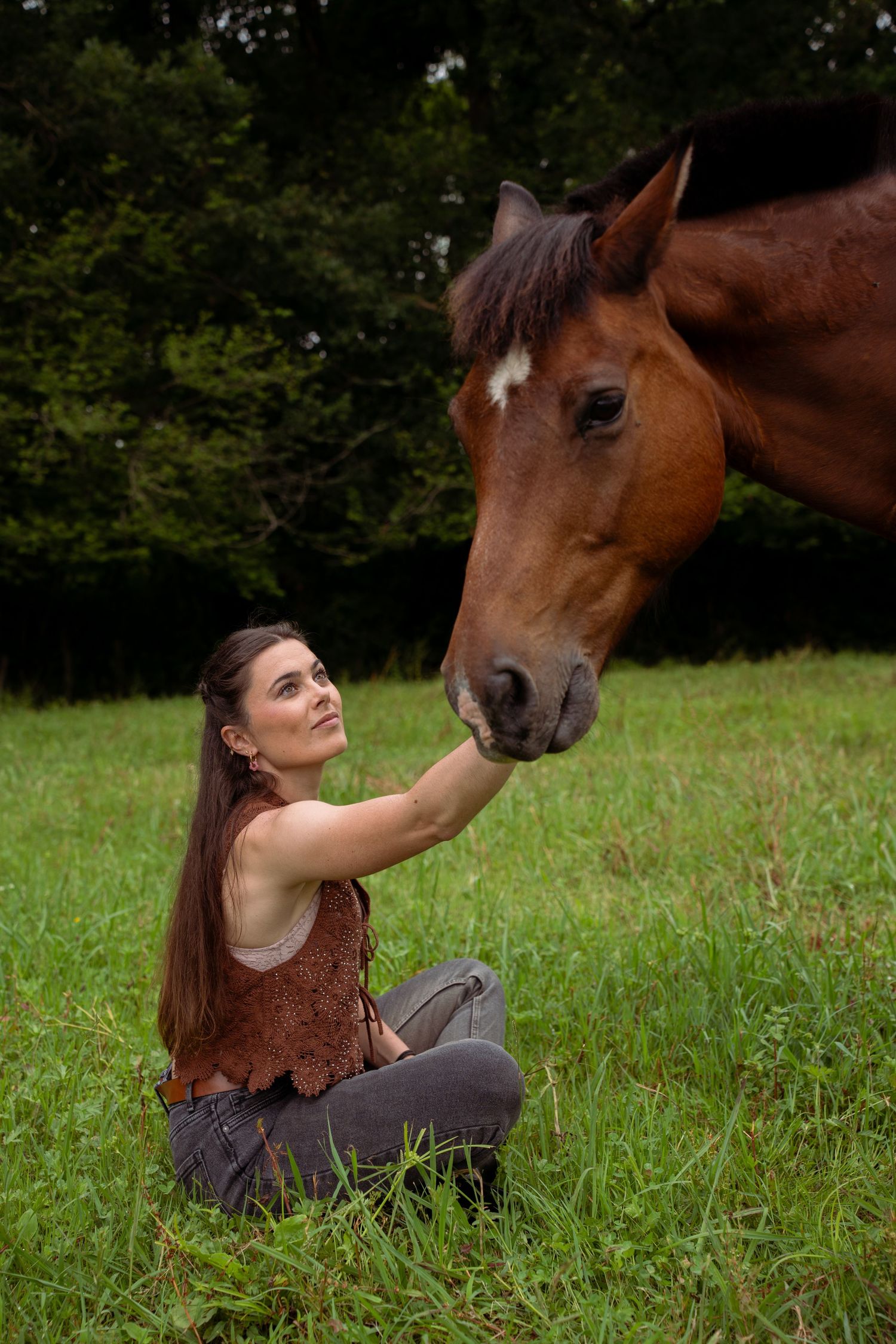Young woman with her horse in natural landscape, soft light, authentic connection between human and animal, peaceful and emotional atmospher