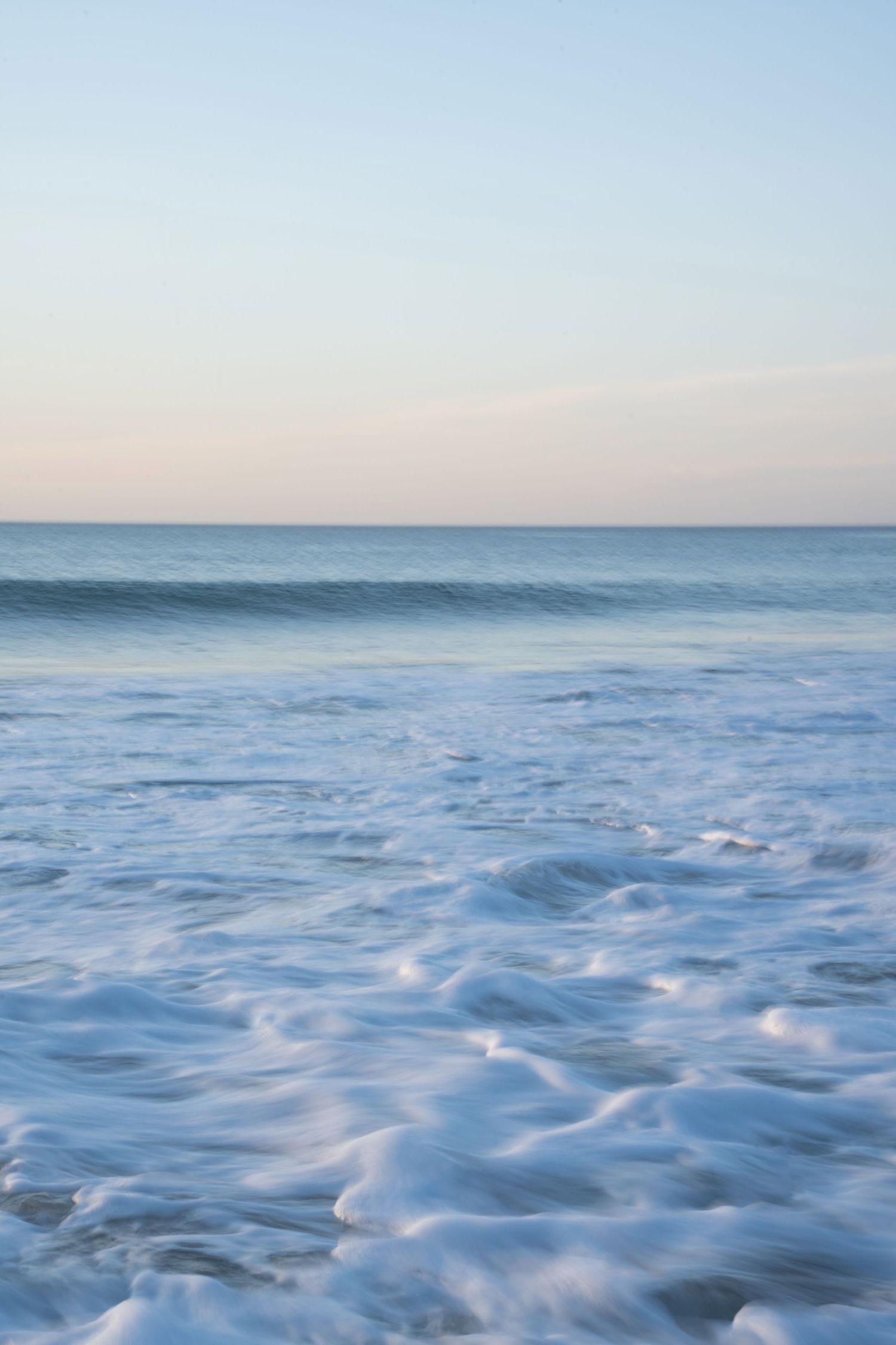 Ocean waves in motion, natural light, powerful movement and calming atmosphere, capturing the rhythm of the sea.
