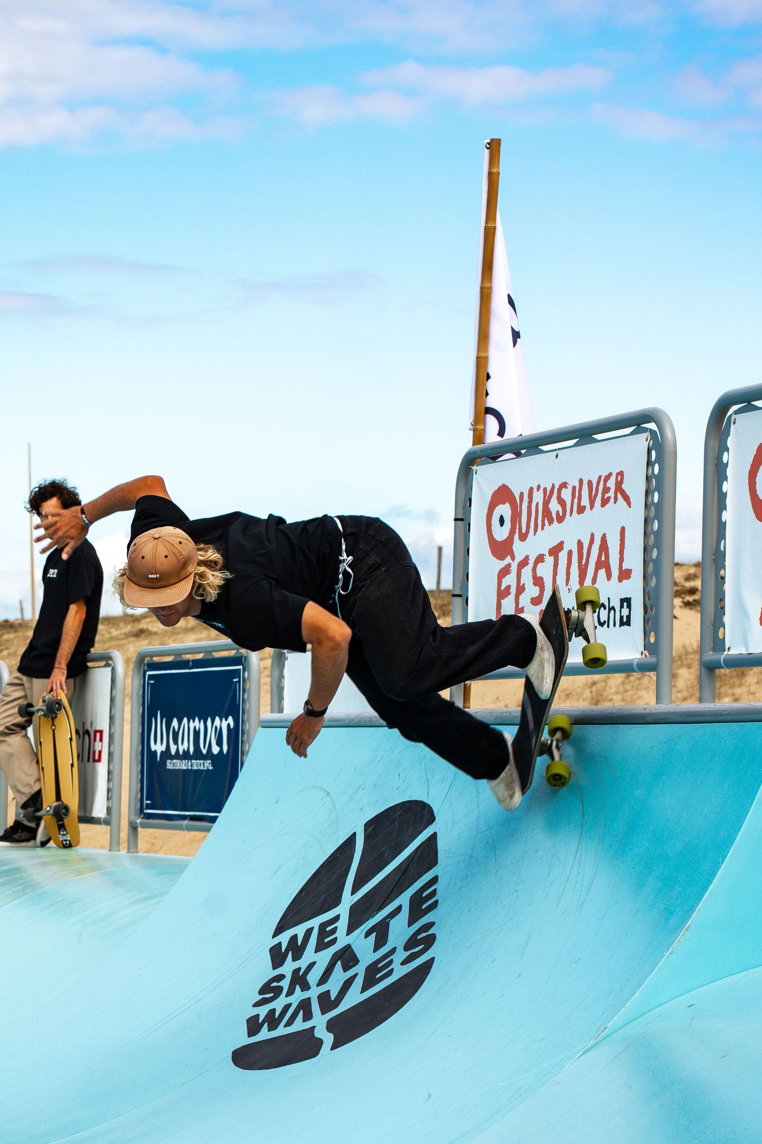 Skateboard competition on the beach, athletes performing tricks with ocean in the background, dynamic movement and vibrant summer atmosphere