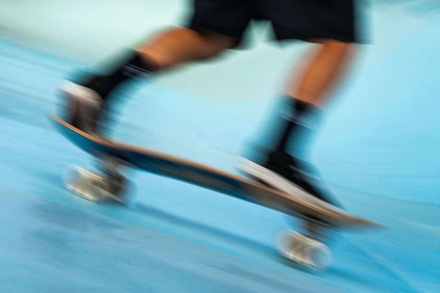 Skateboard competition on the beach, athletes performing tricks with ocean in the background, dynamic movement and vibrant summer atmosphere