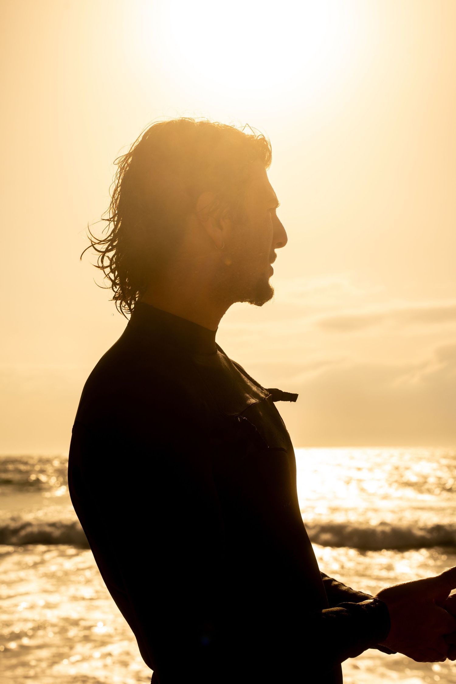 Surf photoshoot at the beach, surfers riding waves in golden light, freedom, movement and cinematic summer mood.
