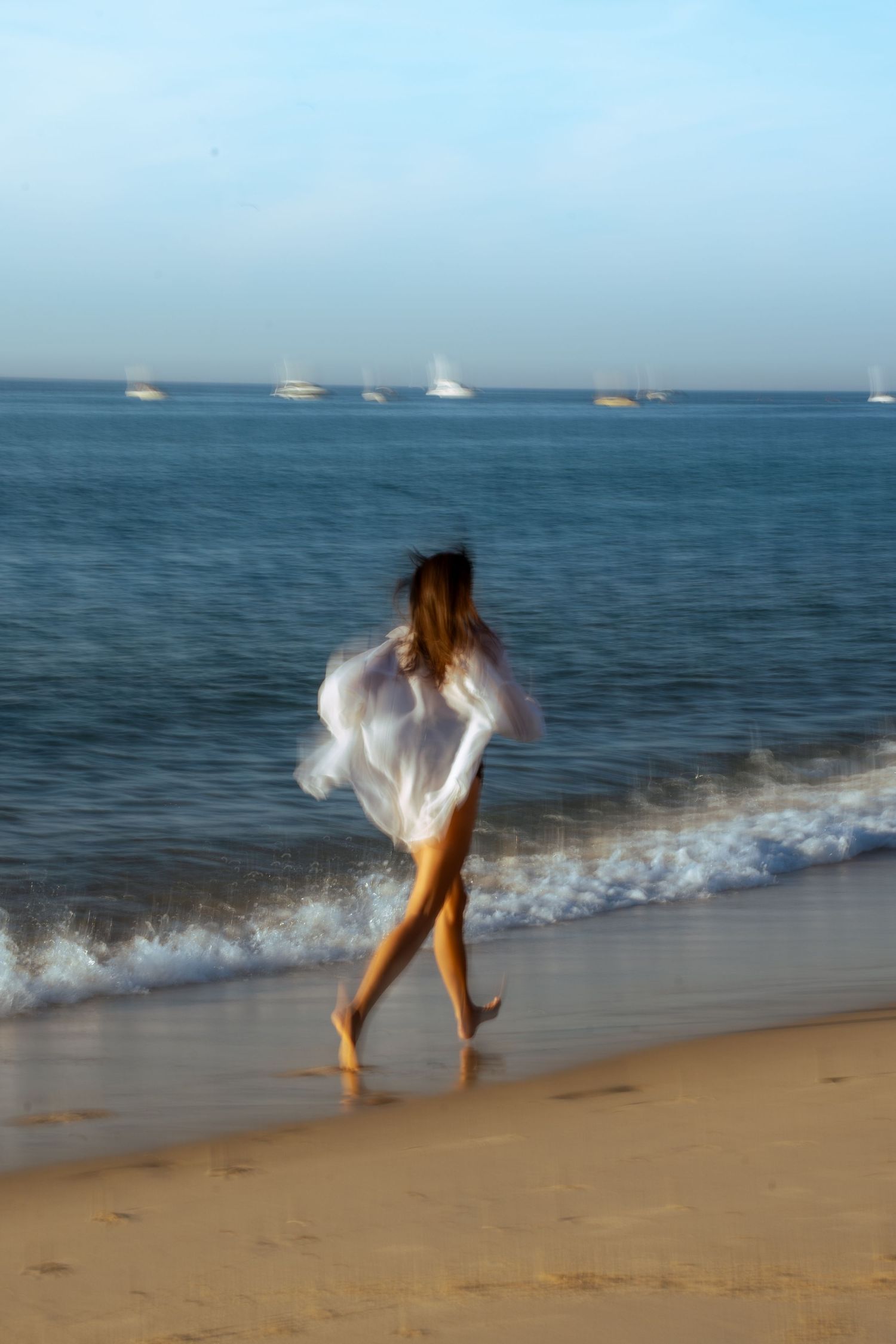 Portrait of a woman on the beach in warm natural light, with ocean and soft tones creating a cinematic mood.