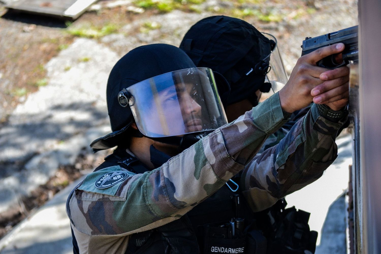 Professional photography of gendarmerie officers during training exercise, dynamic action, teamwork and intensity captured in natural light.