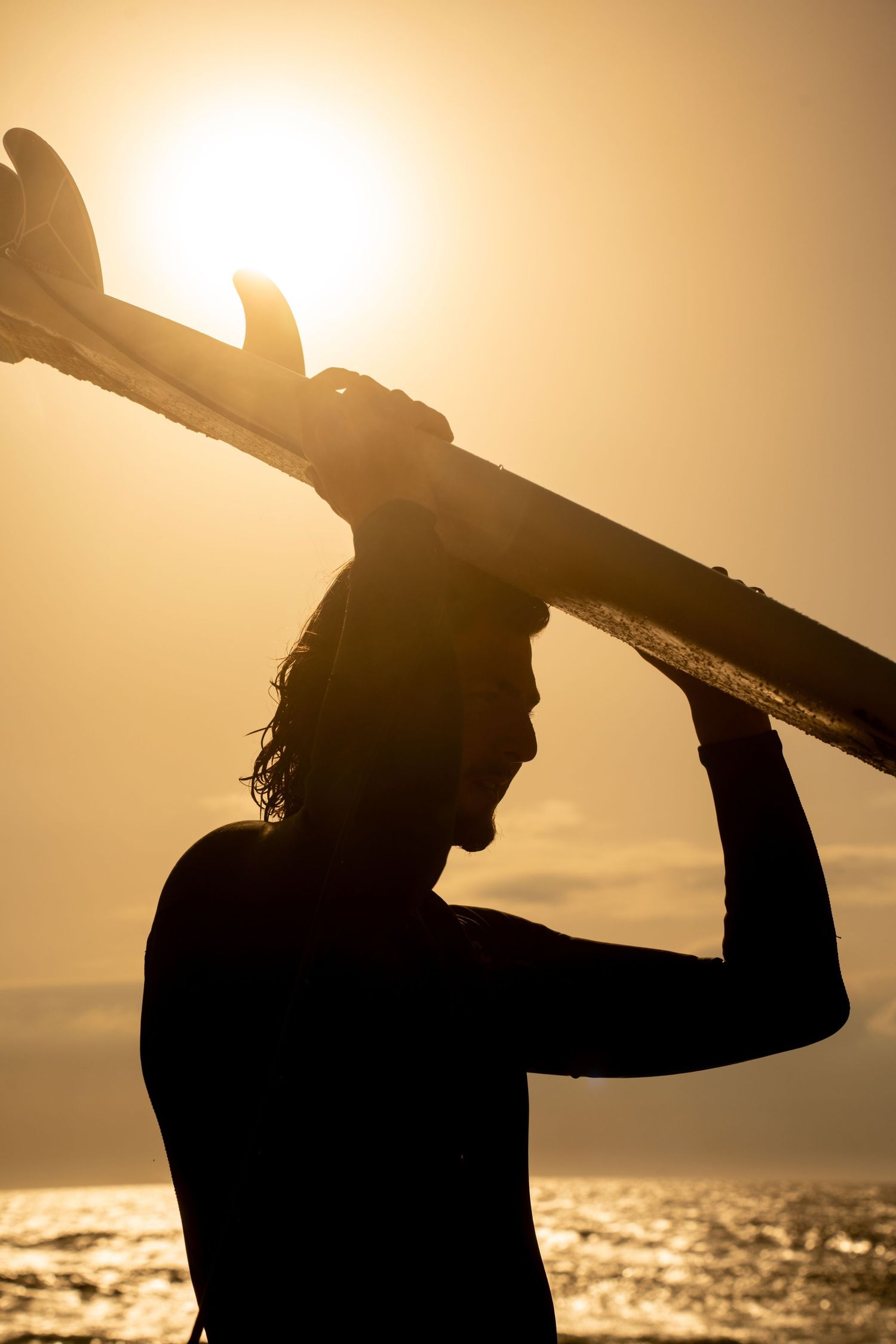 Surf photoshoot at the beach, surfers riding waves in golden light, freedom, movement and cinematic summer mood.