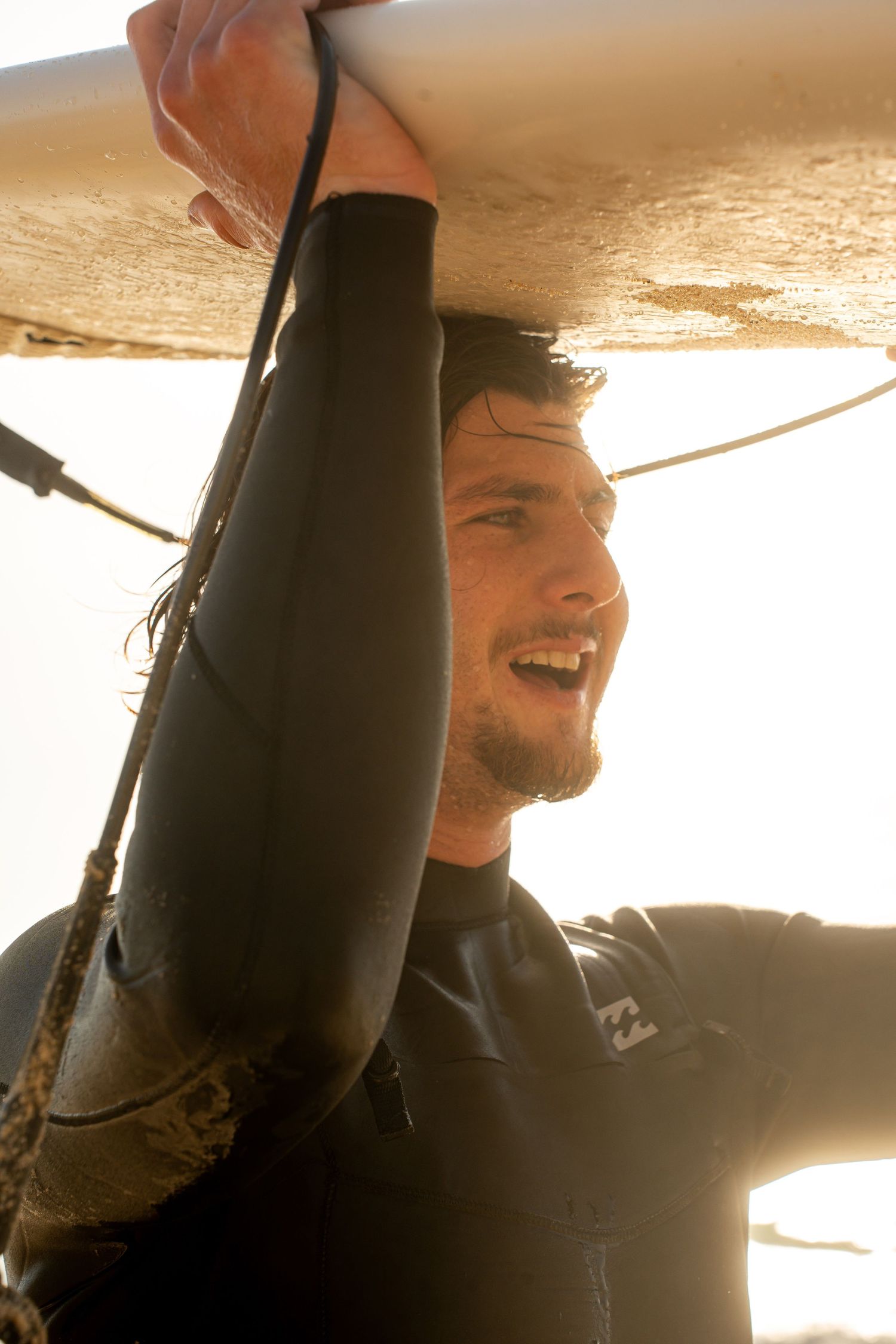 Surf photoshoot at the beach, surfers riding waves in golden light, freedom, movement and cinematic summer mood.