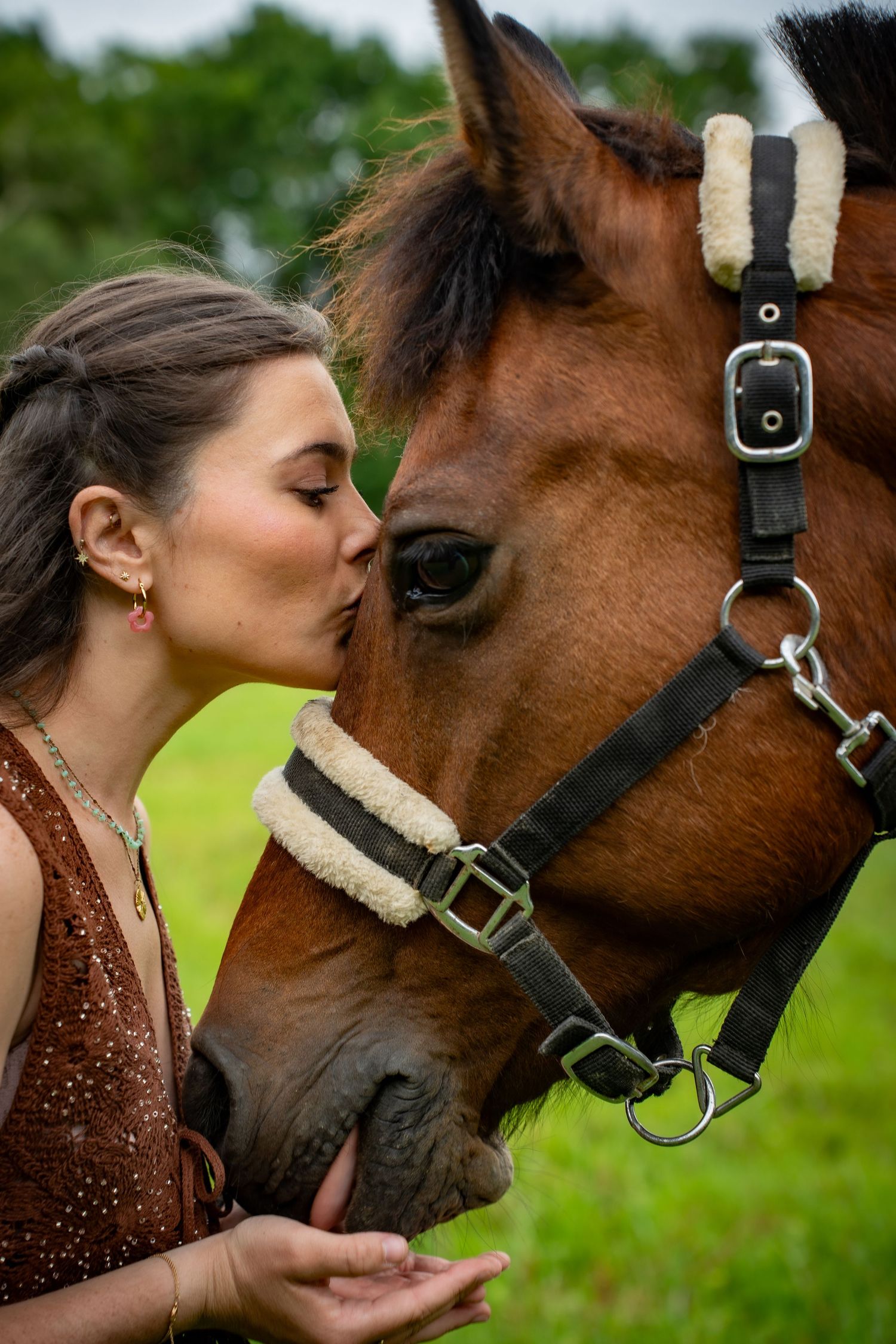 Young woman with her horse in natural landscape, soft light, authentic connection between human and animal, peaceful and emotional atmospher