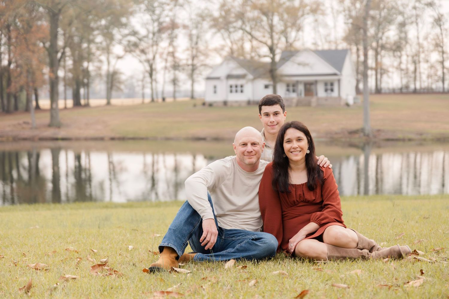 Couple lounging on grass during outdoor photo session.