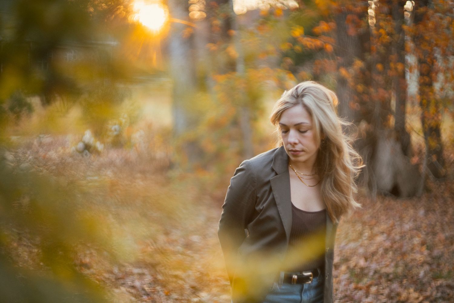Autumn photography session with golden sunlight filtering through trees.